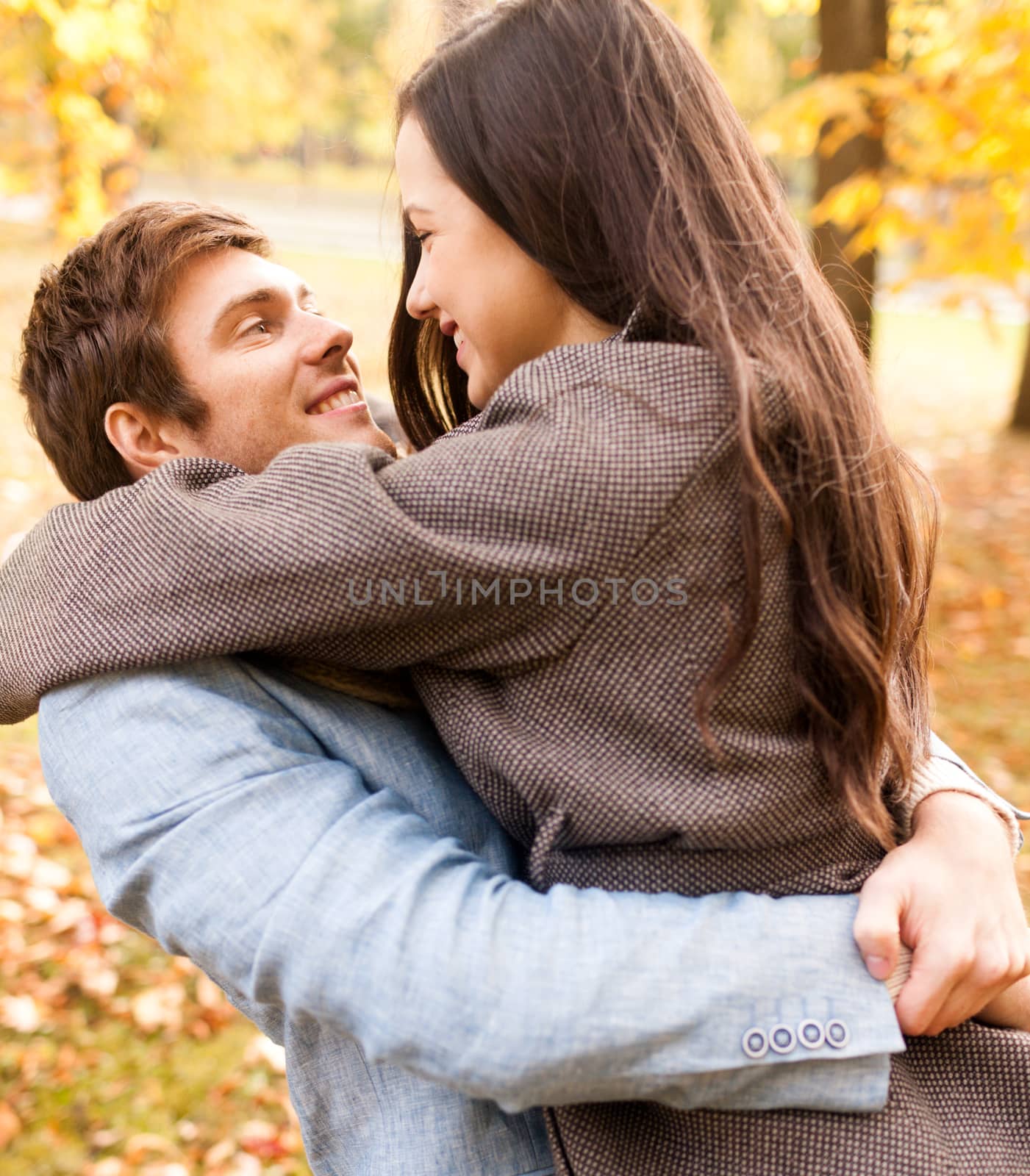 smiling couple hugging in autumn park by dolgachov