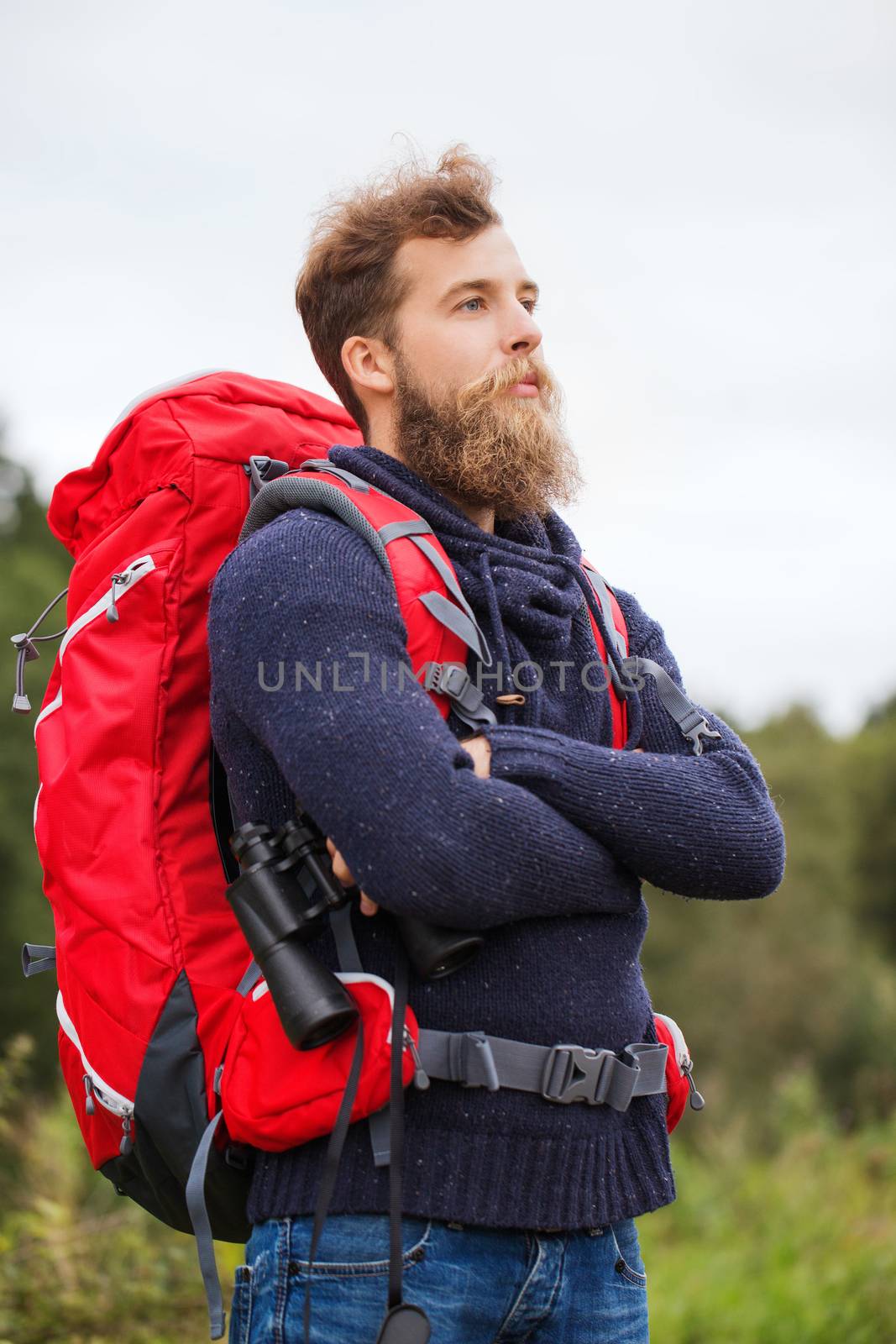 adventure, travel, tourism, hike and people concept - man with red backpack and binocular outdoors