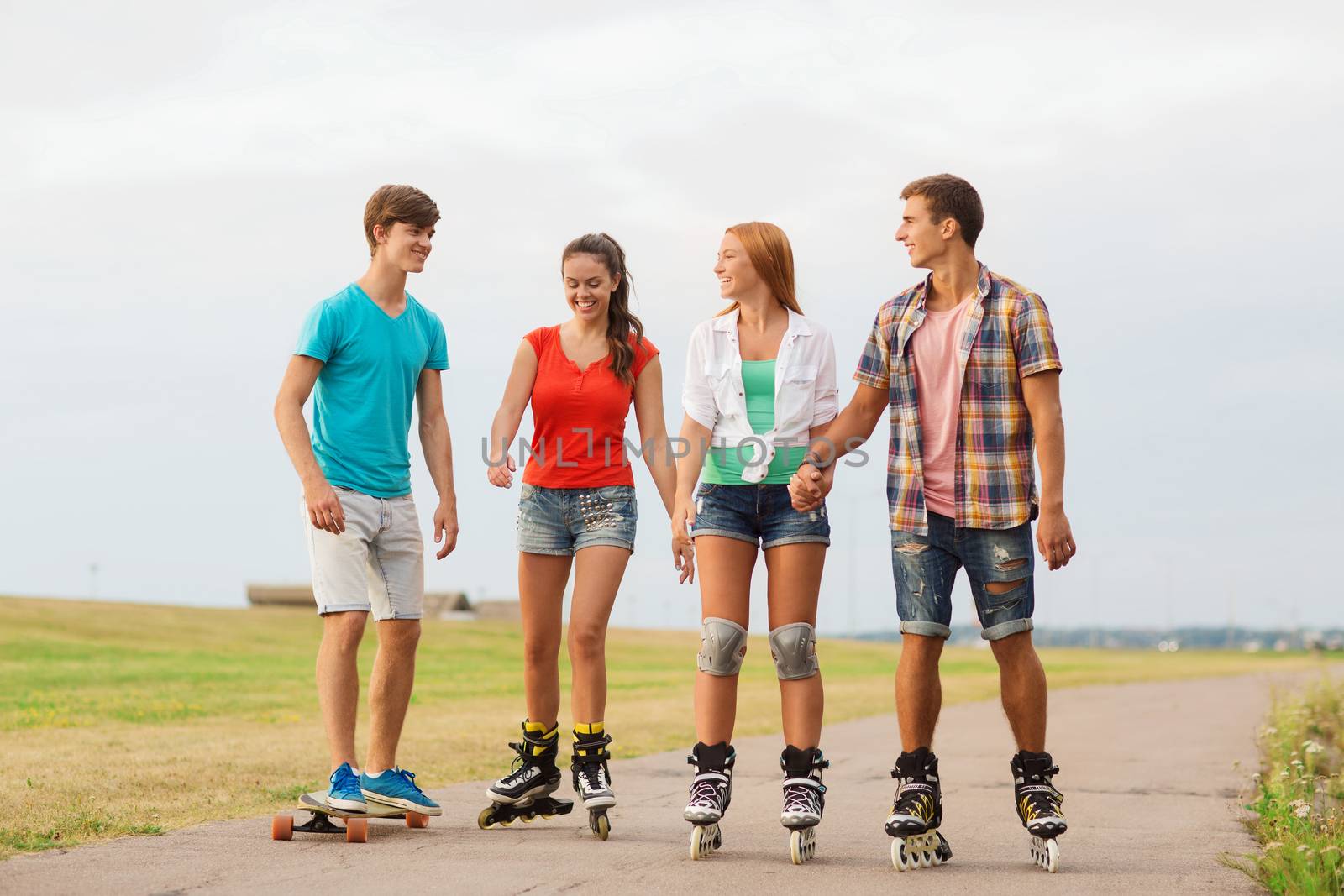 group of smiling teenagers with roller-skates by dolgachov