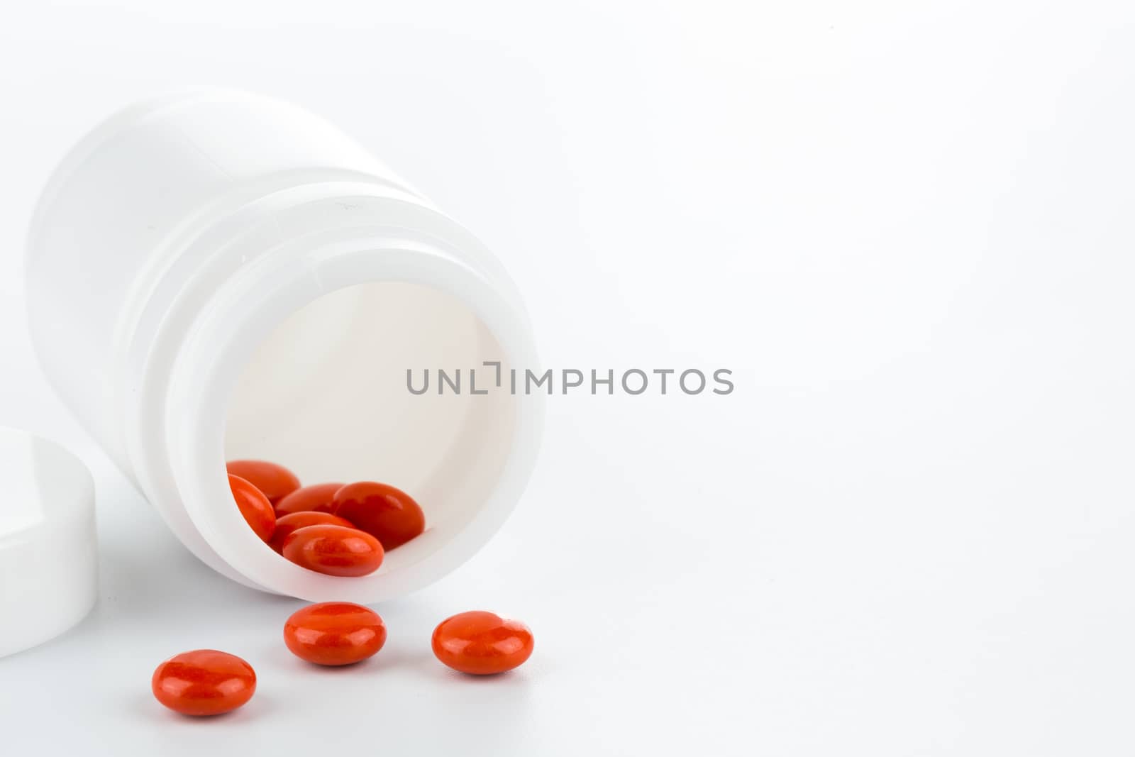 red pills an pill bottle on white background by urubank