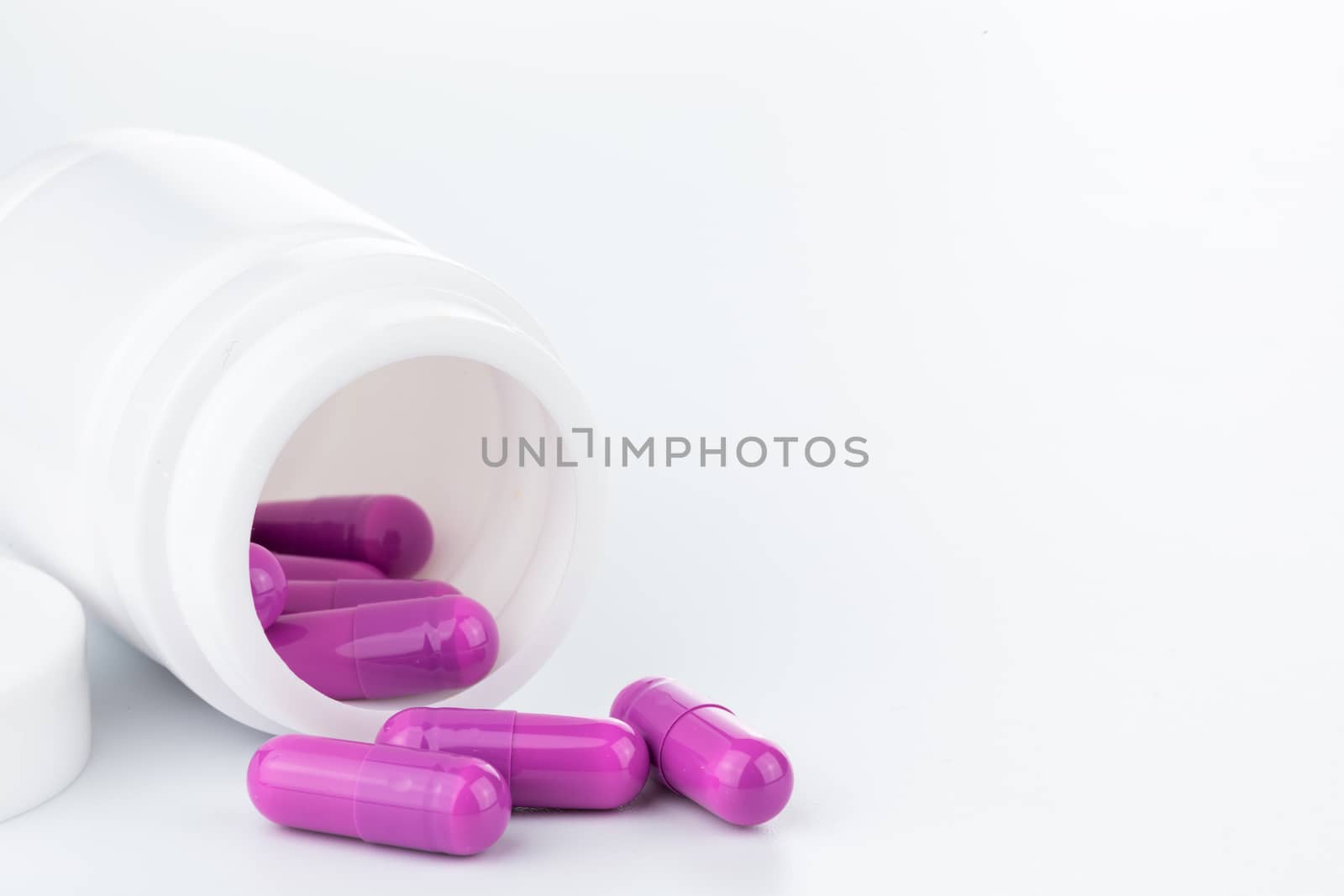 purple pills an pill bottle on white background (Isolated)