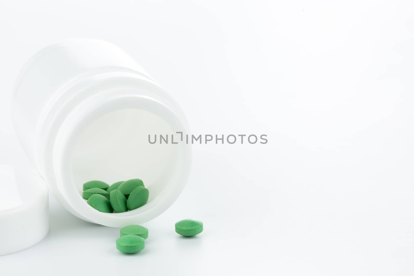 green pills an pill bottle on white background (Isolated)