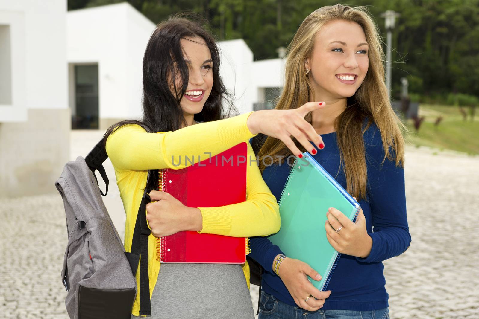 Two beautiful teenage students in the school looking somewhere