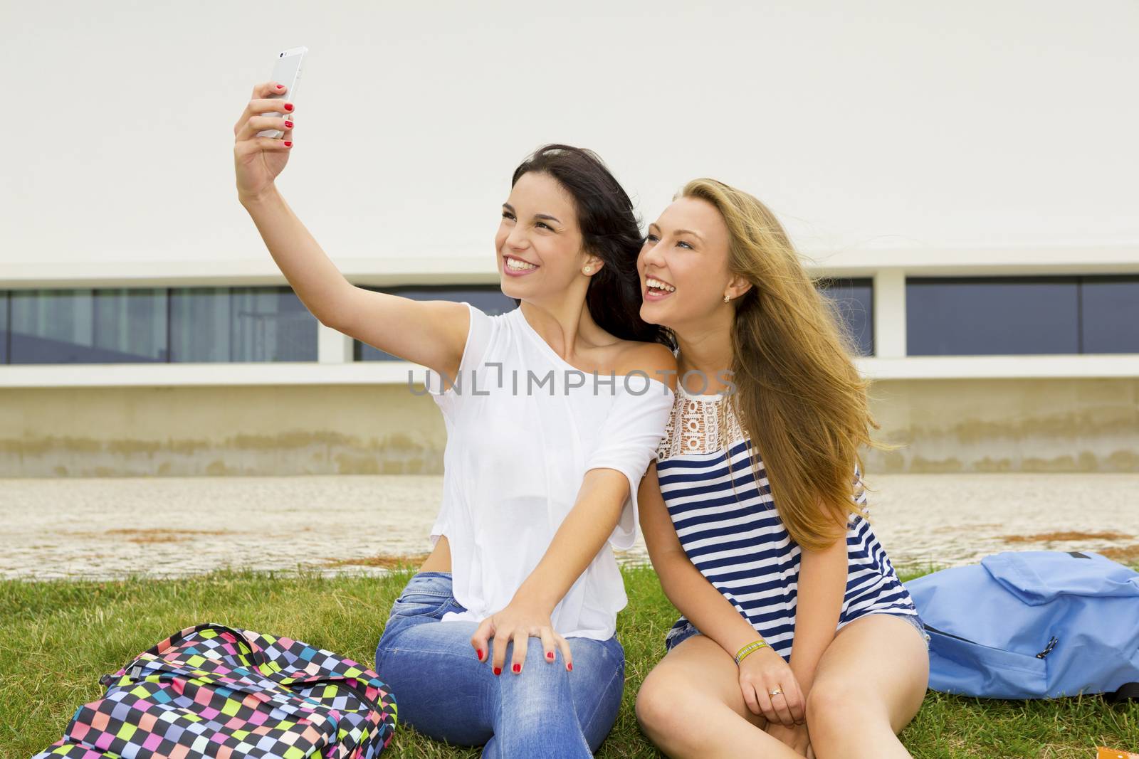 Two beautiful and happy studentsg making a selfie