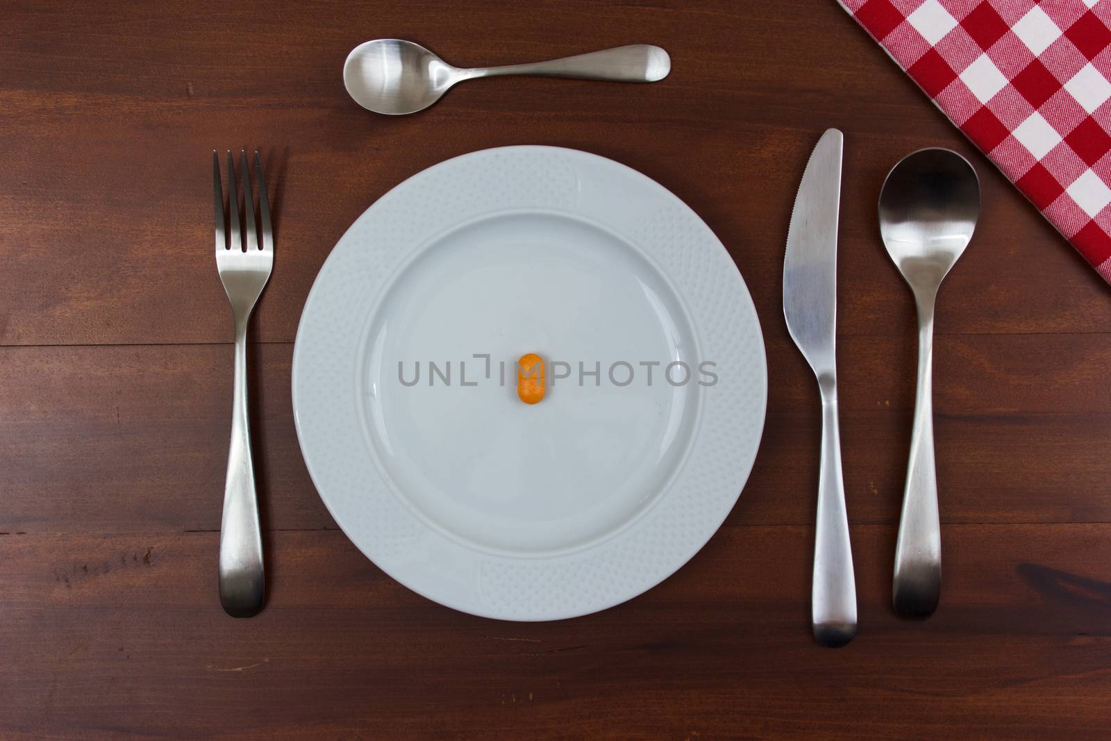 white dish with cutlery and pills on wooden table