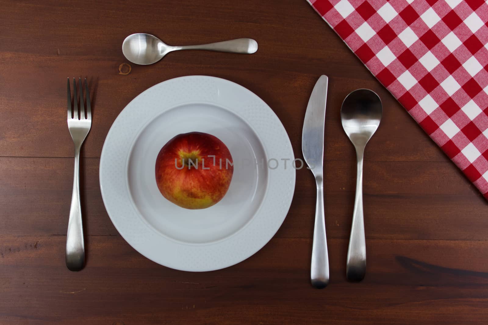 apple on a white plate by goghy73