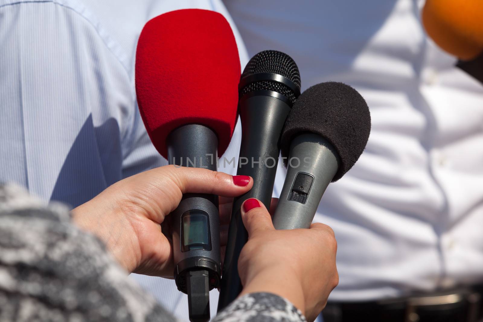 Broadcast journalism. Reporters taking interview at news conference.