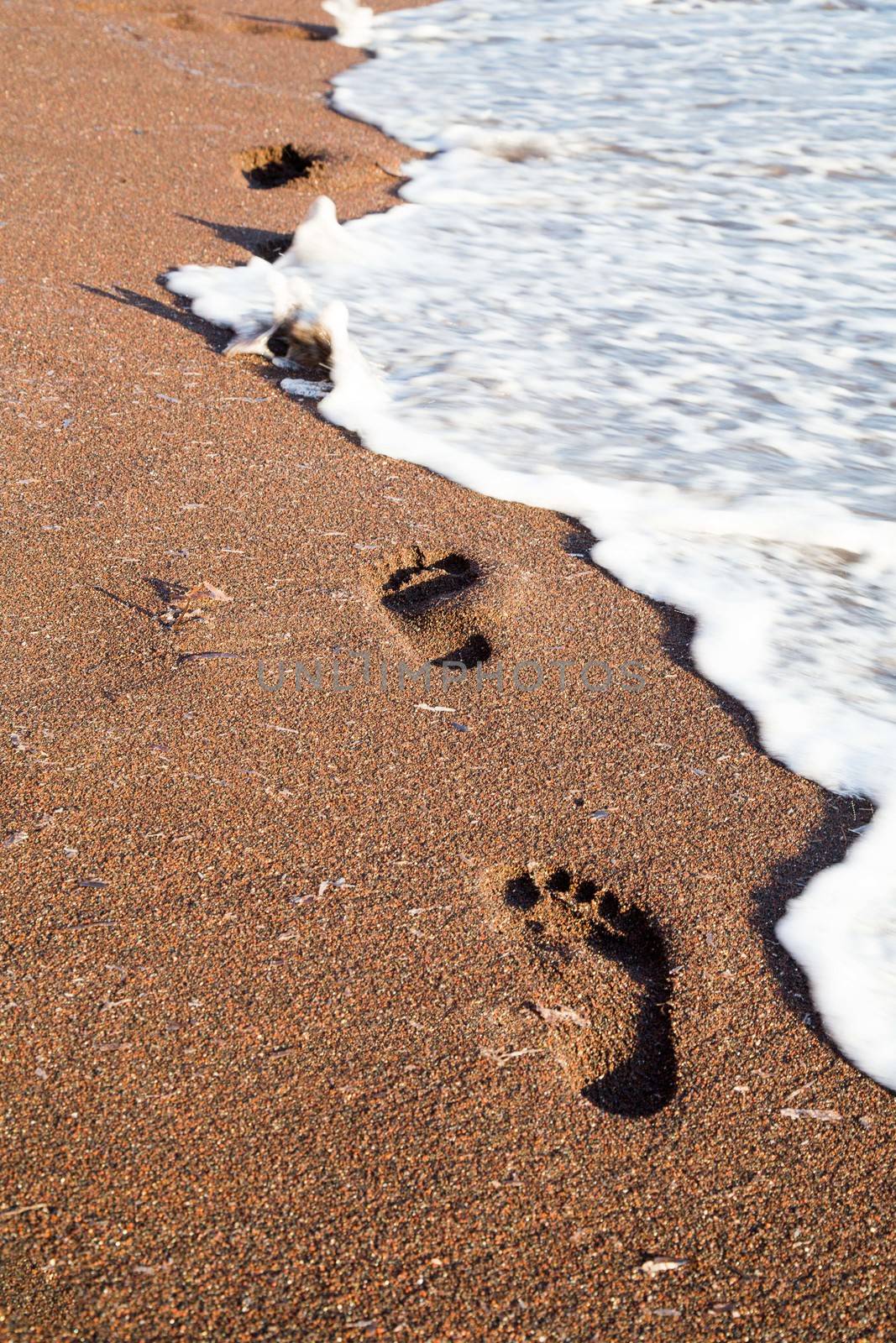 Trail of foot steps on the beach
