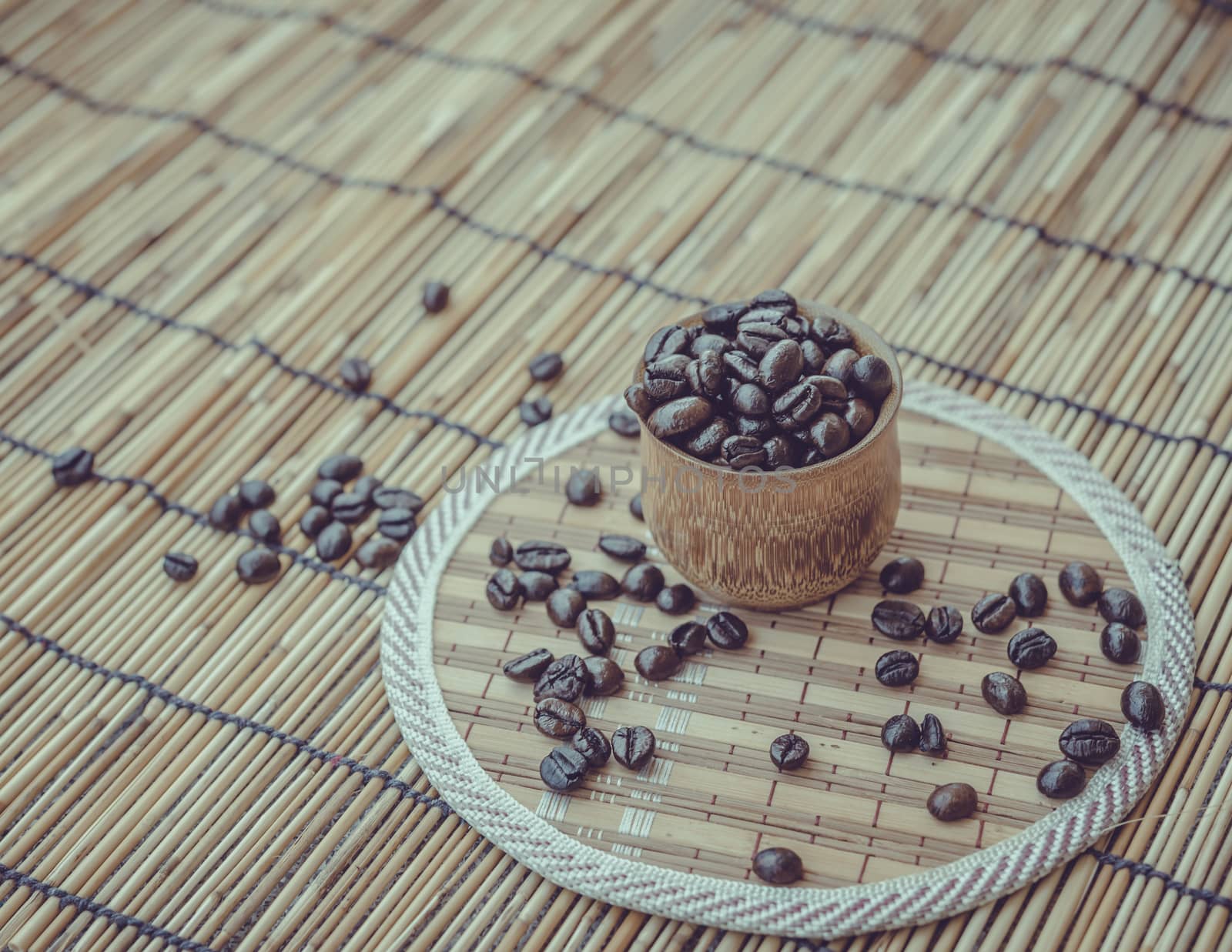 Coffee beans and coffee cup set on bamboo wooden background.Photo in retro color image style, Soft focus.