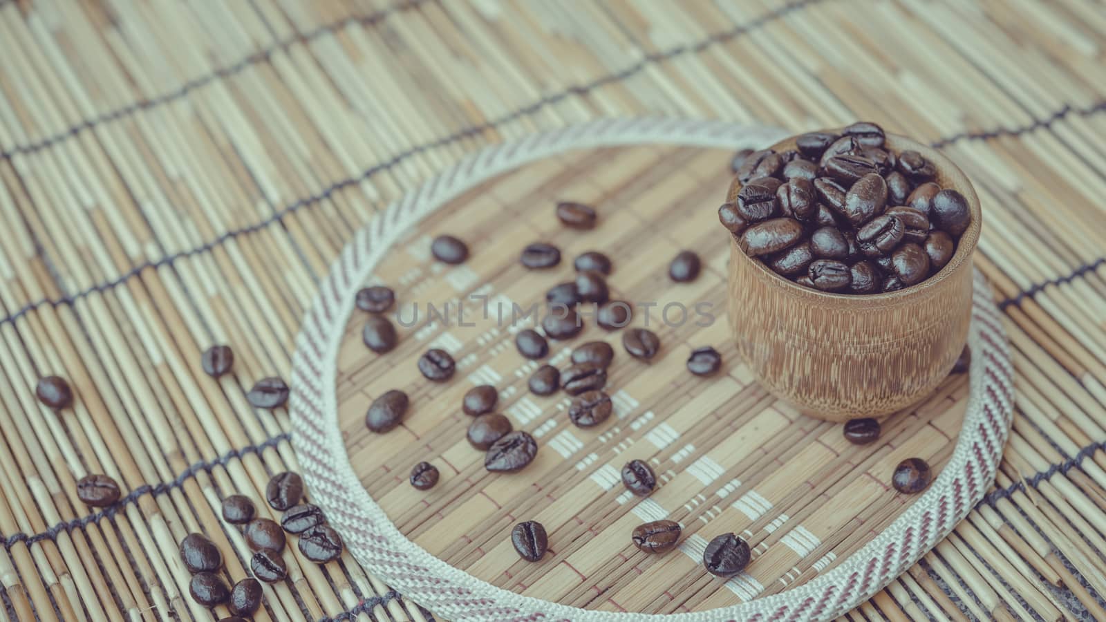 Coffee beans and coffee cup set on bamboo wooden background.Photo in retro color image style, Soft focus.