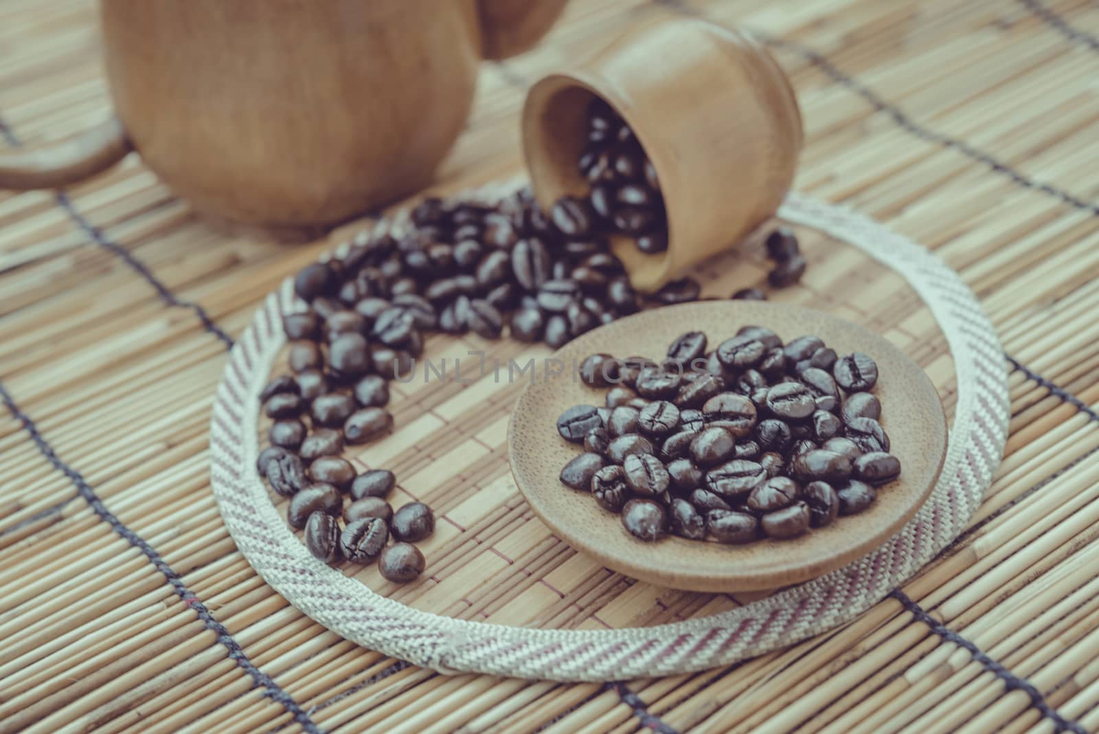 Coffee beans and coffee cup set on bamboo wooden background.Photo in retro color image style, Soft focus.