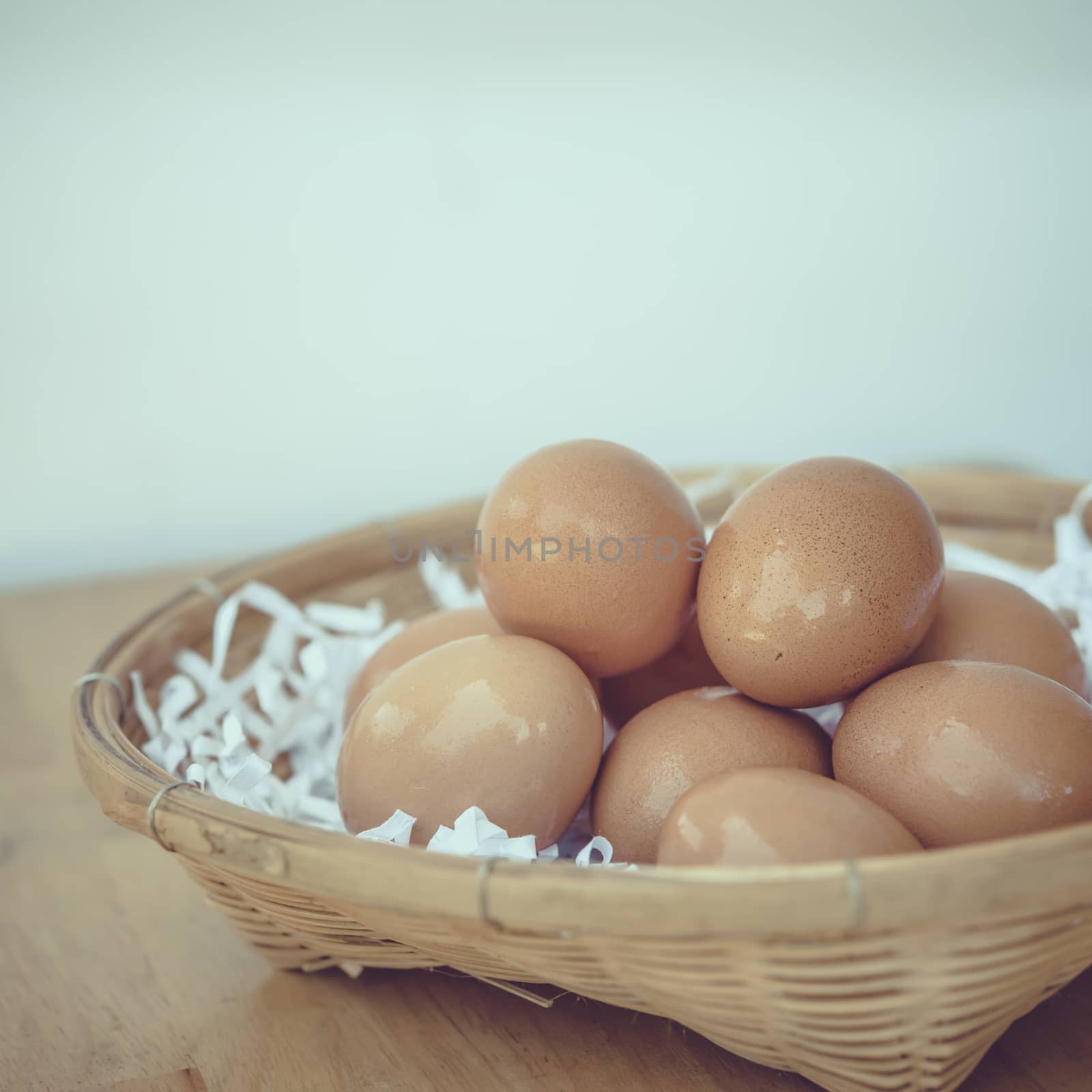 Eggs in a wicker basket on a wooden table