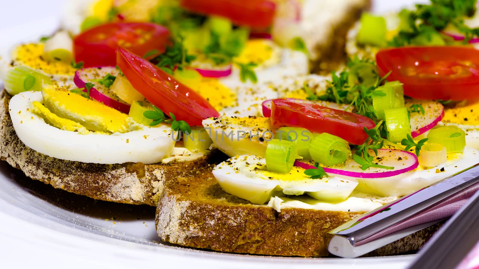 Healthy snack - wholemeal bread with egg tomatos and fresh cress and radishes