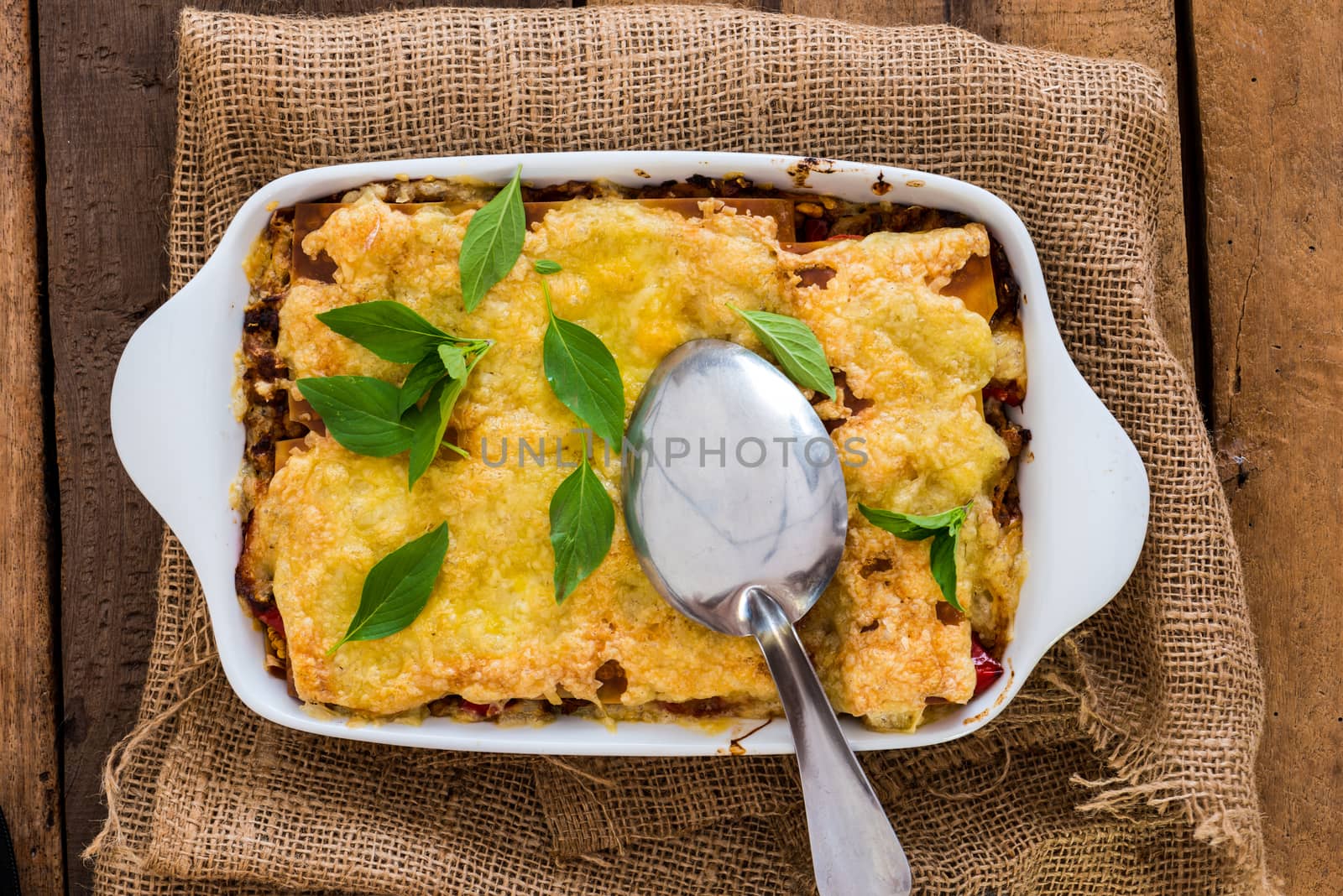 Top view of a plate with lasagna a traditional italian dish on wood table