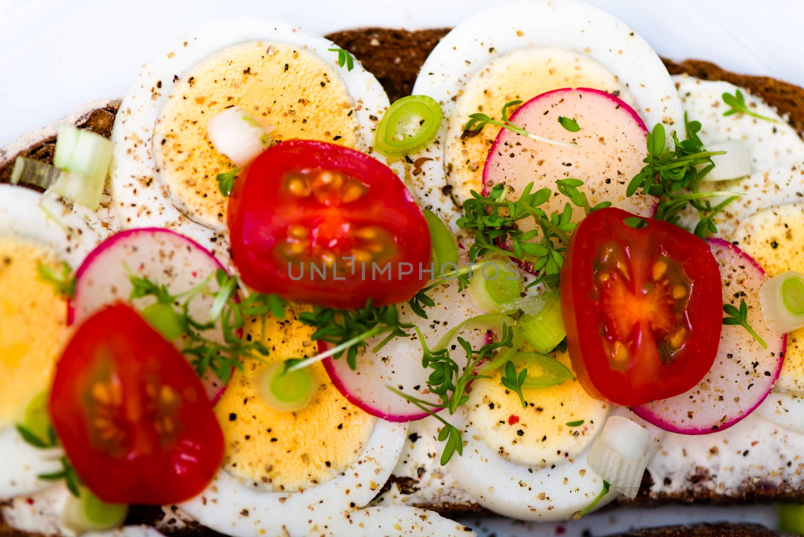 Healthy snack - wholemeal bread with egg tomatos and fresh cress and radishes