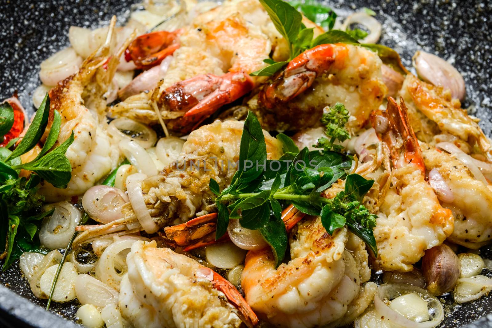 Closeup of shrimps on pan with fresh herbs