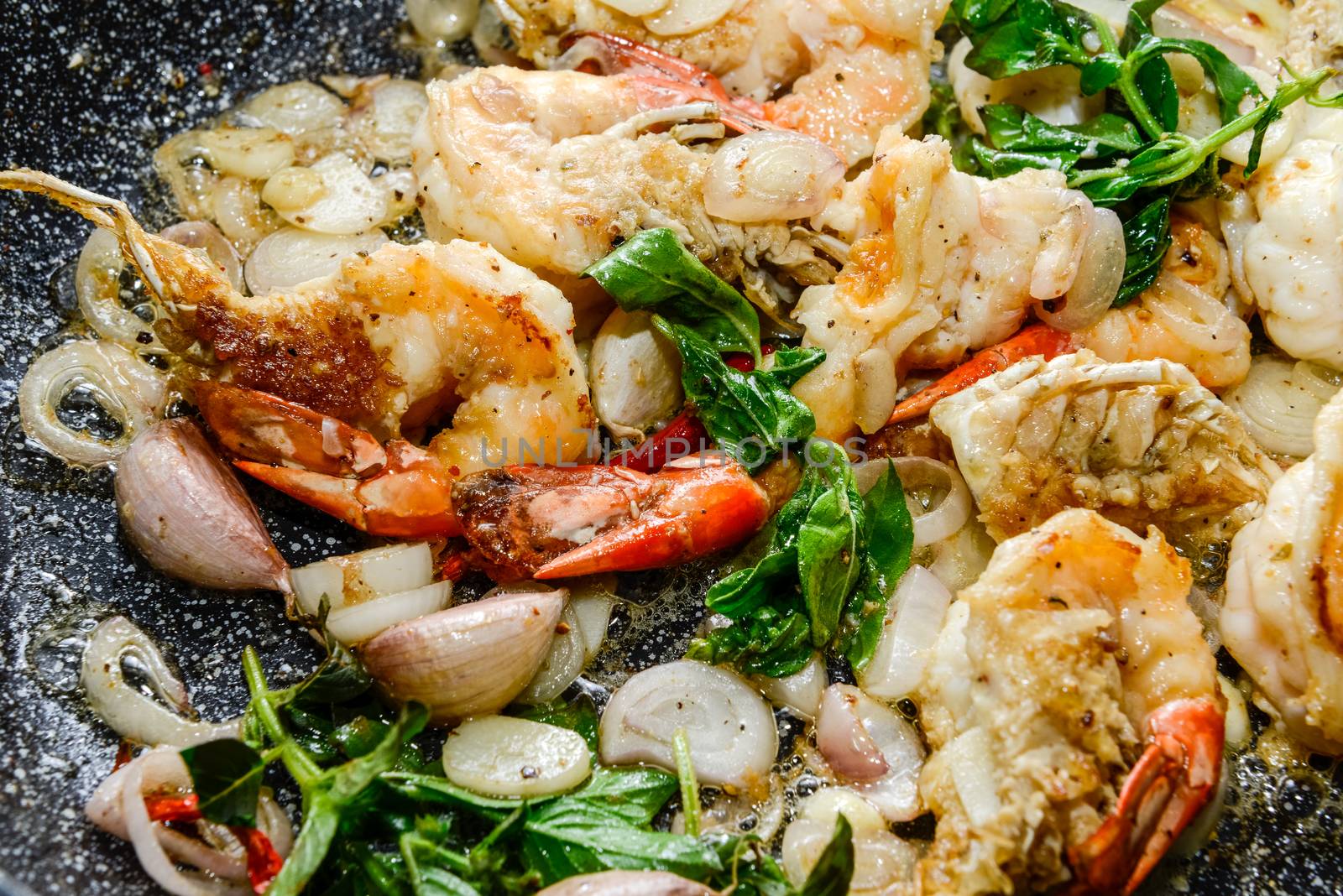 Closeup of shrimps on pan with fresh herbs