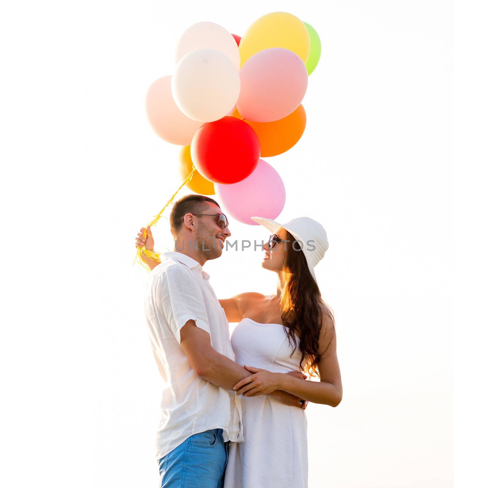 love, wedding, summer, dating and people concept - smiling couple wearing sunglasses with balloons hugging outdoors