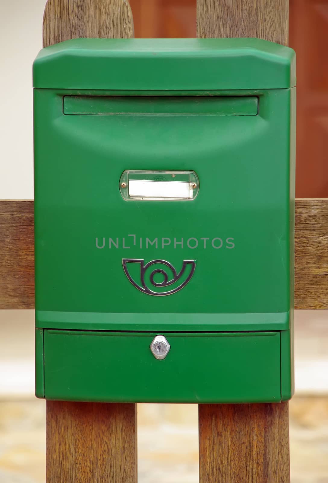 A green plastic mailbox mounted on a wall