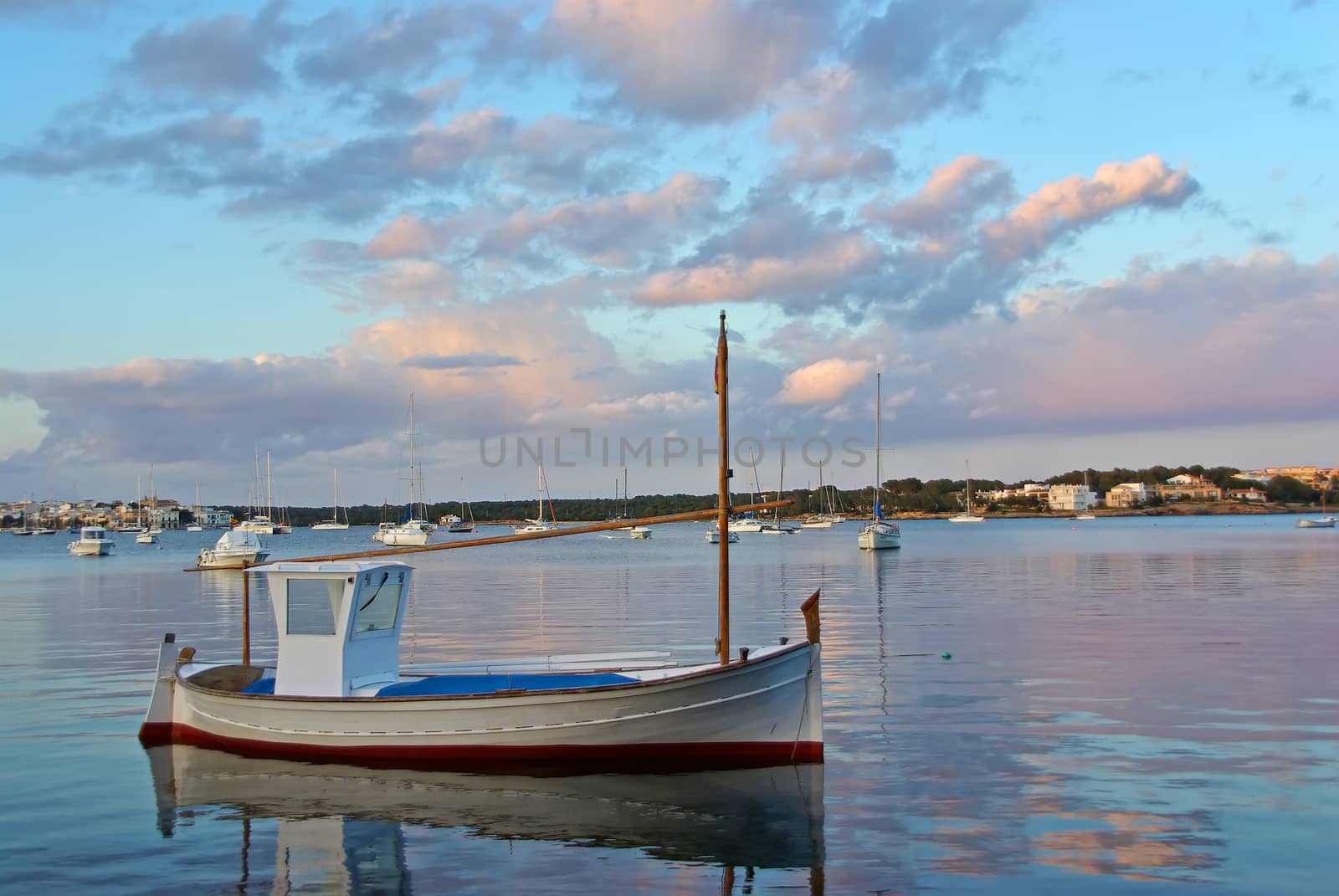 View of a boat in the Porto olom bay in Majorca (Spain) at sunset time