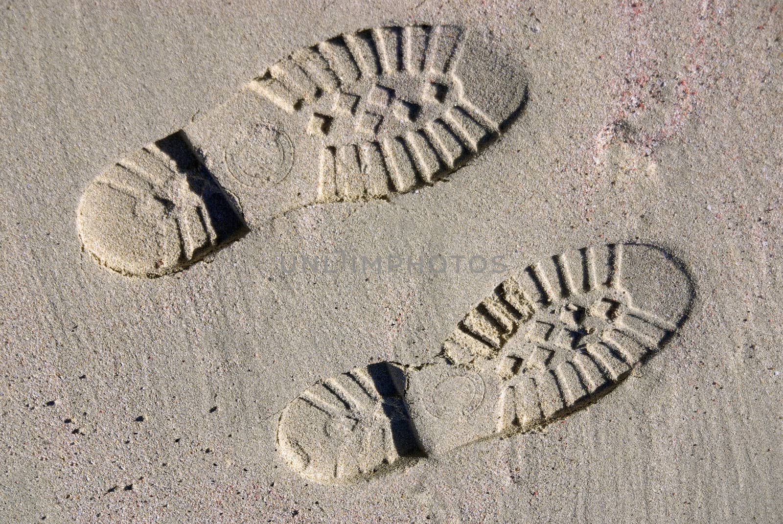 Boot footprints on the sand of a beach