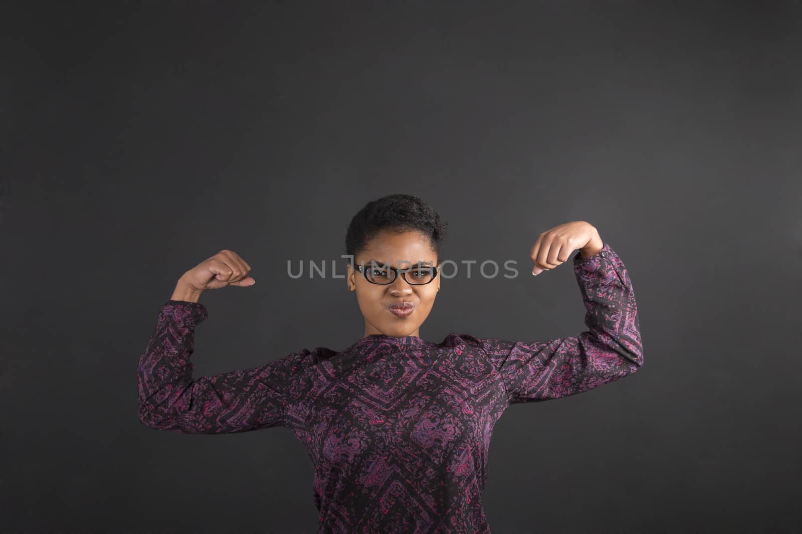 African woman with strong arms on blackboard background by alistaircotton