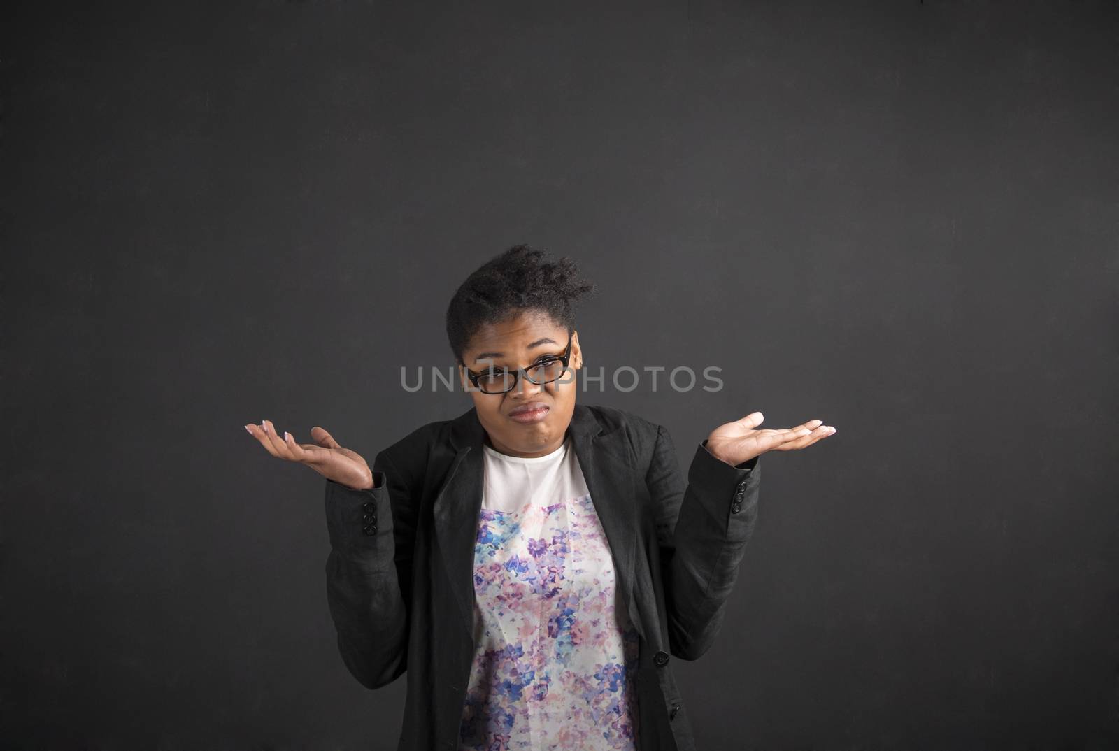 African woman with an I don't know gesture on blackboard background by alistaircotton