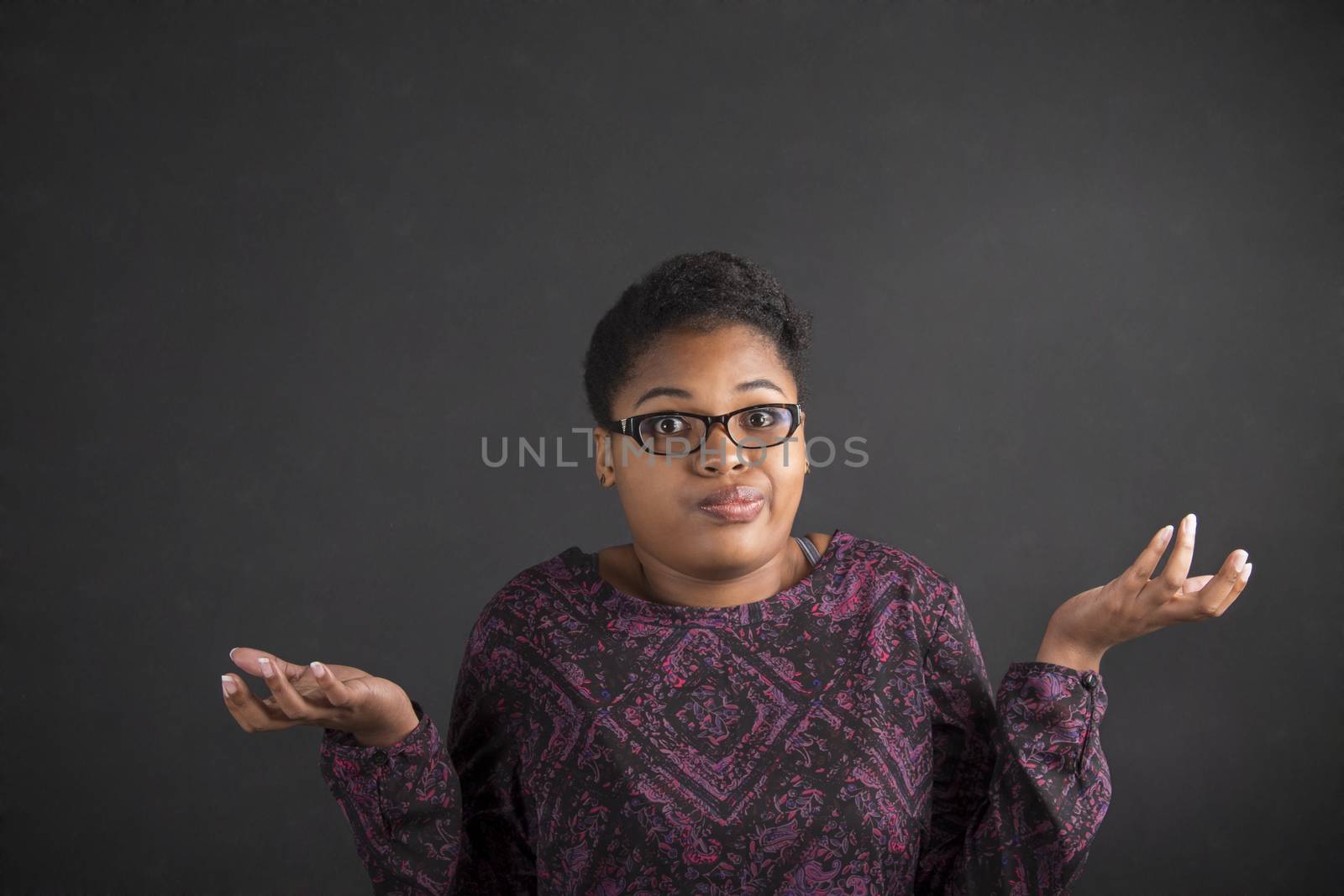 African woman with an I don't know gesture on blackboard background by alistaircotton