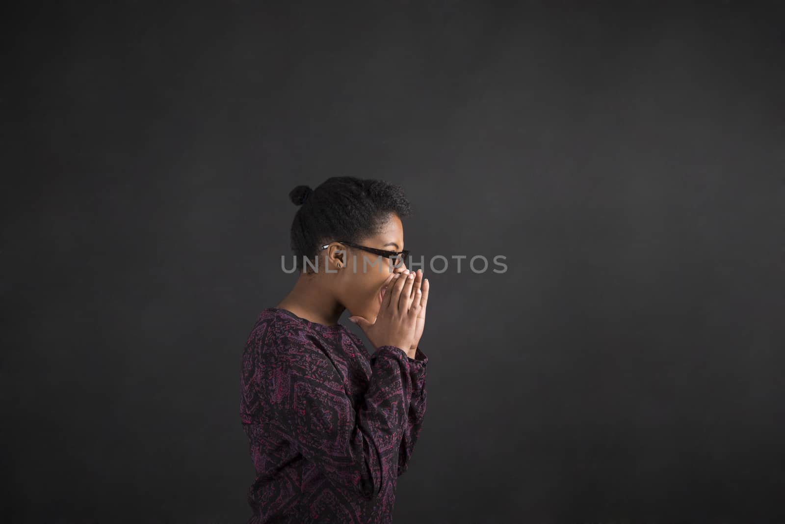 African woman shouting or screaming on blackboard background by alistaircotton