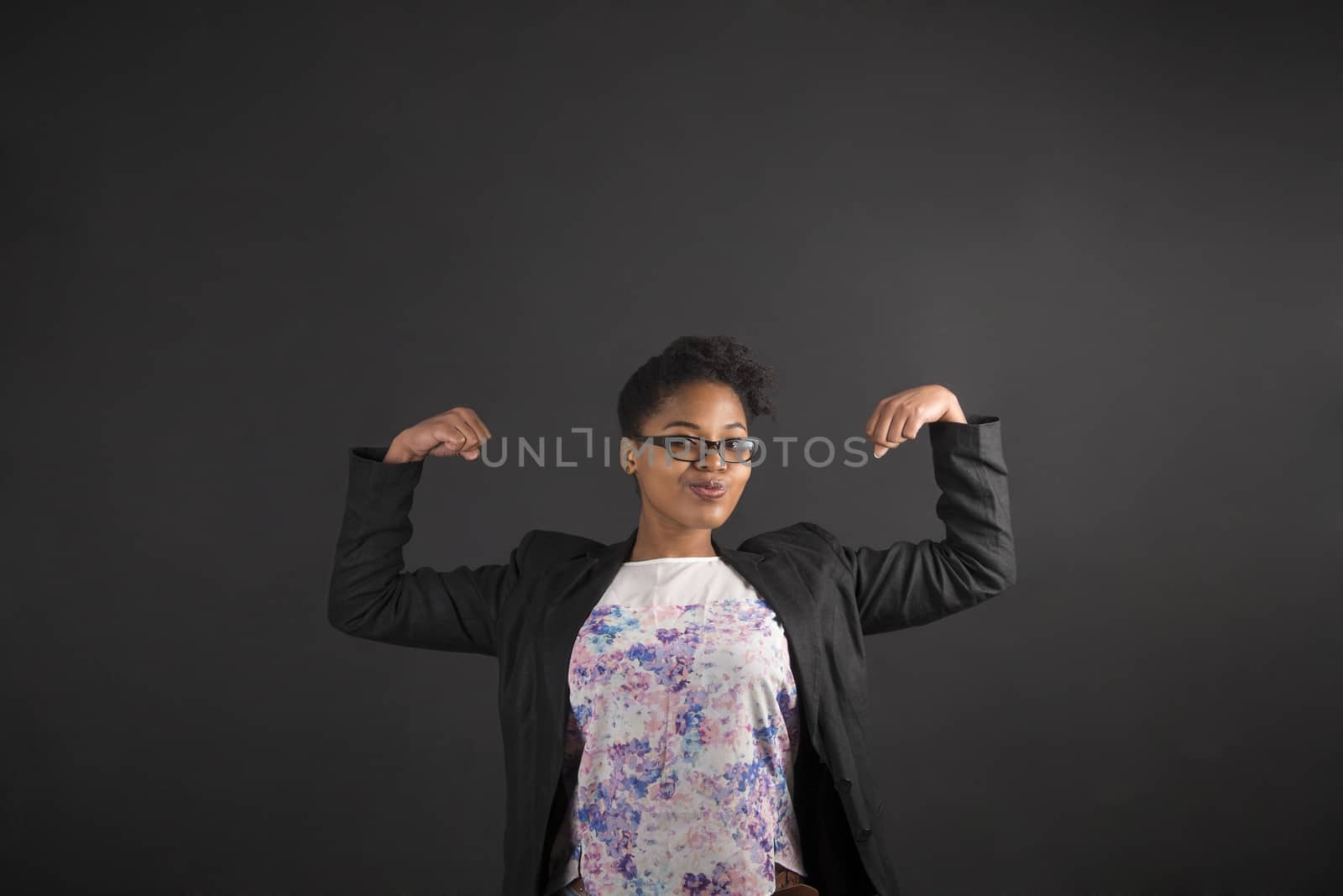 African woman with strong arms on blackboard background by alistaircotton