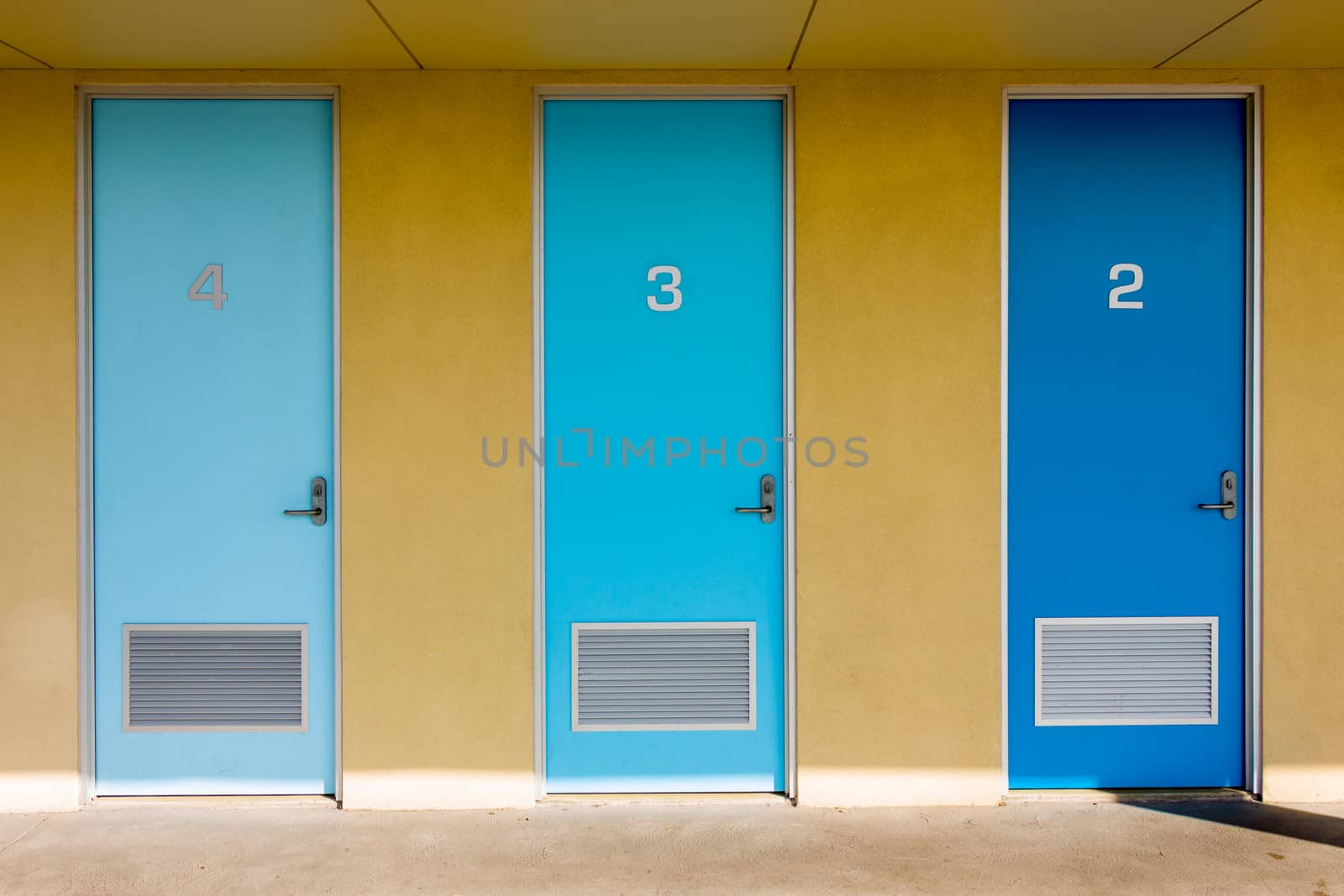 Three doors of different shades of blue.