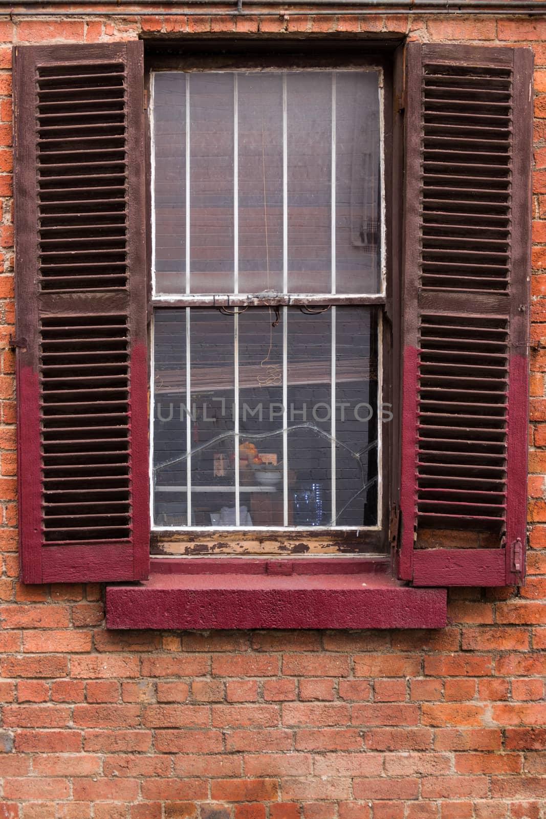 Open window shutters on an old, crumbling building.