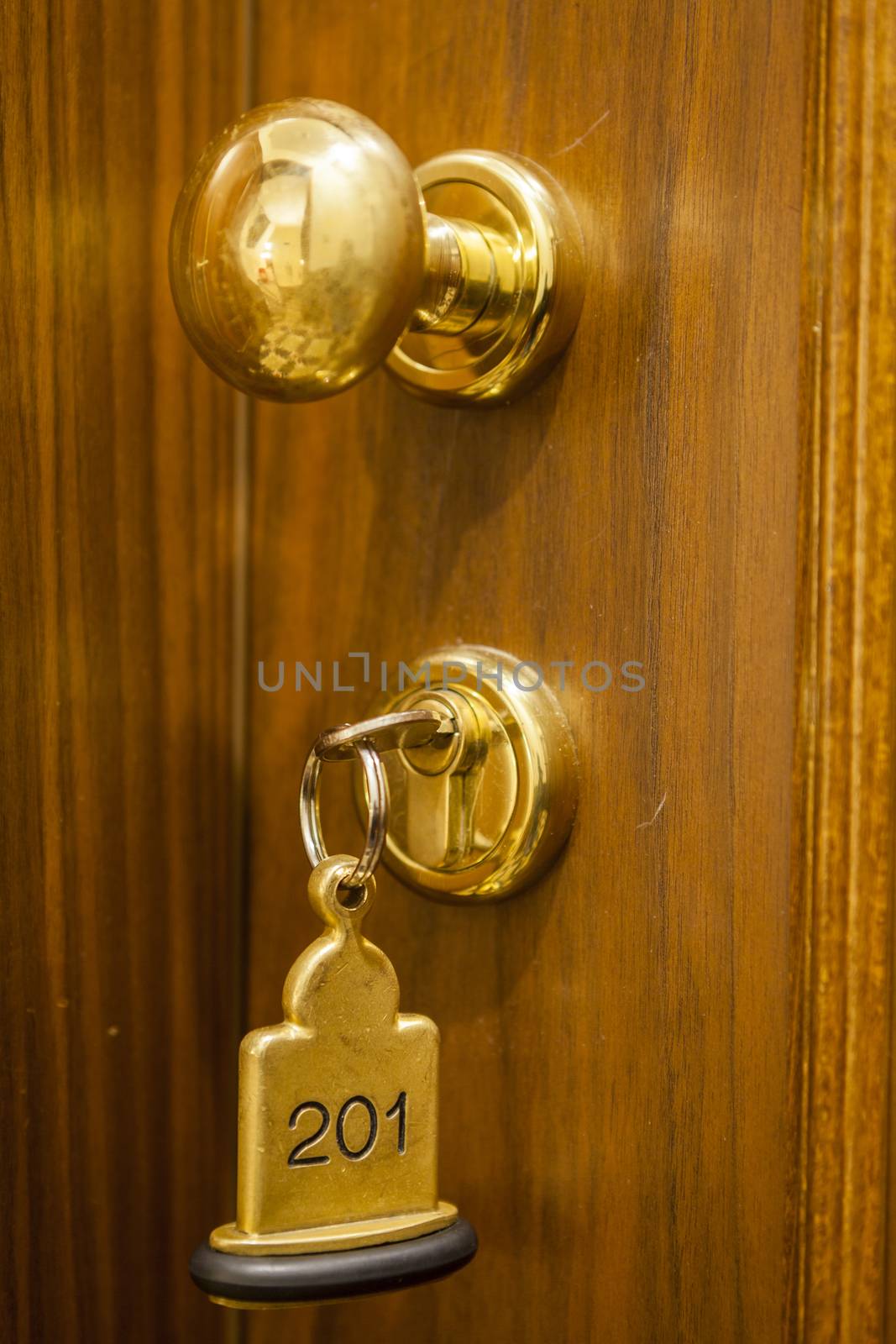 Hotel Room Key lying on Bed with keyring golden