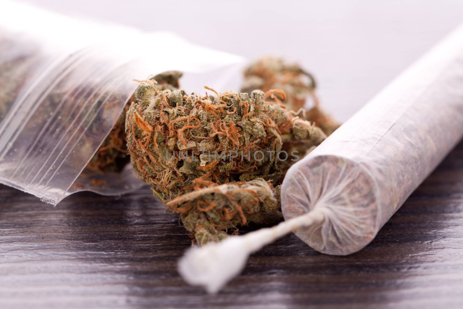 Close up of dried marijuana leaves and joint by juniart