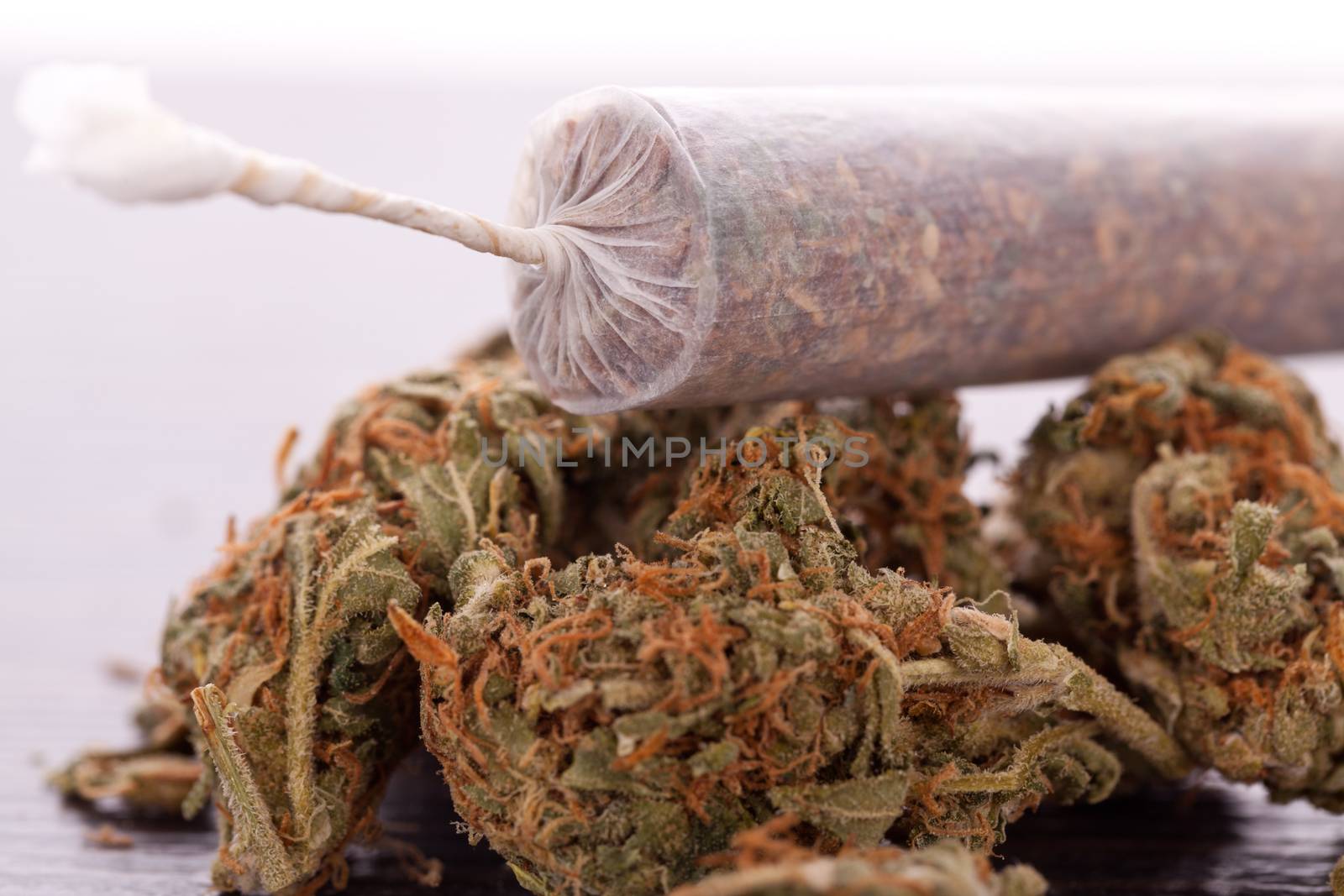 Close up of dried marijuana leaves and joint by juniart