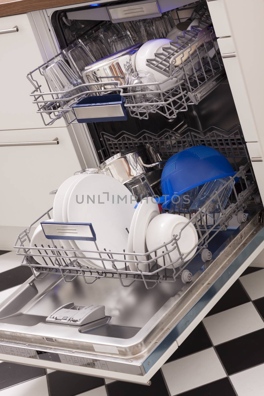 Dishwasher loades in a kitchen with clean dishes and blue light