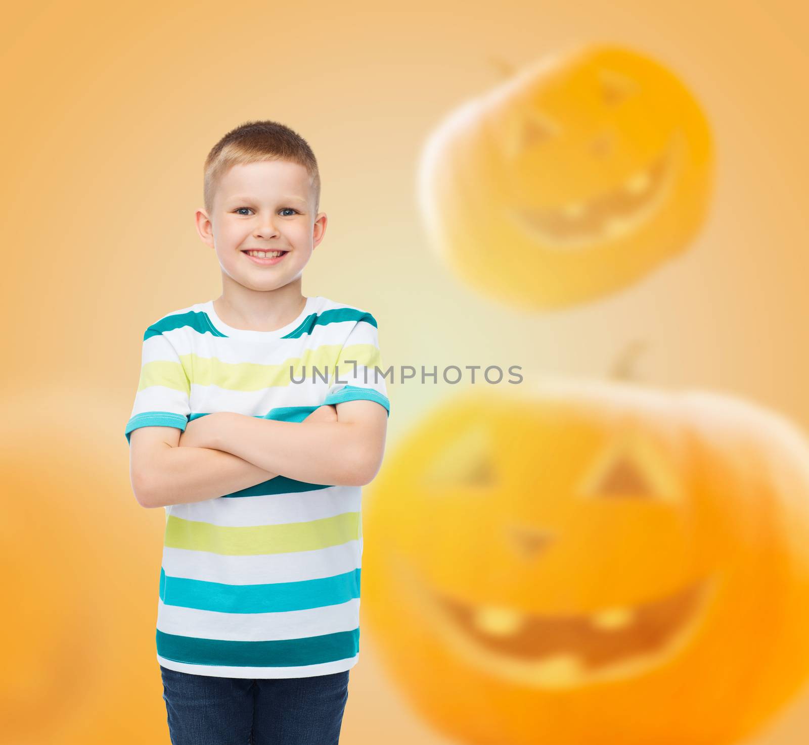 smiling boy over pumpkins background by dolgachov