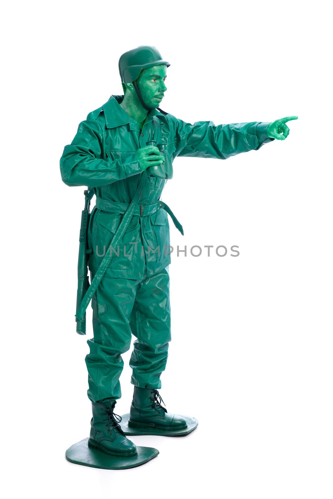 Man on a green toy soldier costume with riffle poiting with his forefinger  isolated on white background.