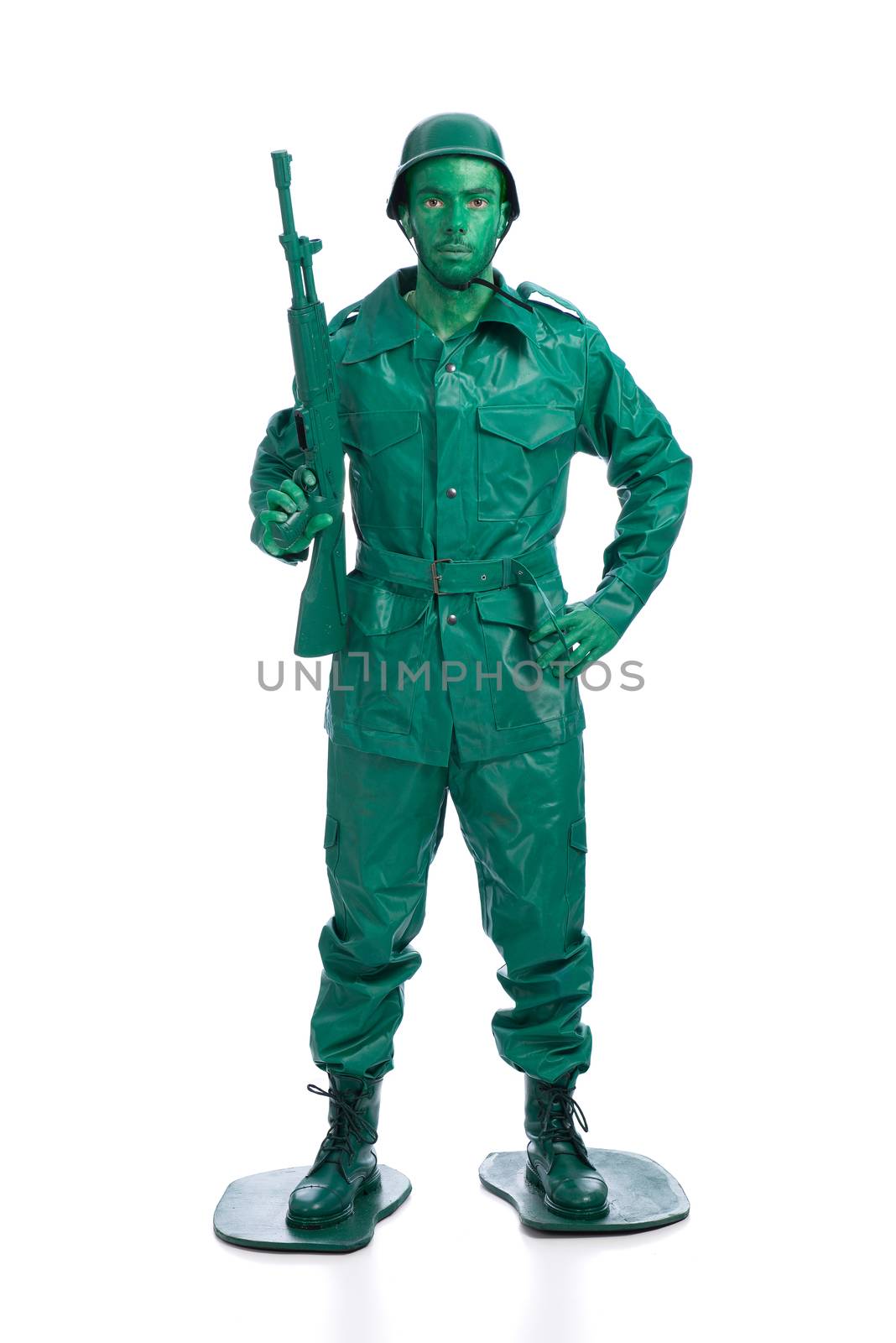 Man on a green toy soldier costume standing with riffle isolated on white background.