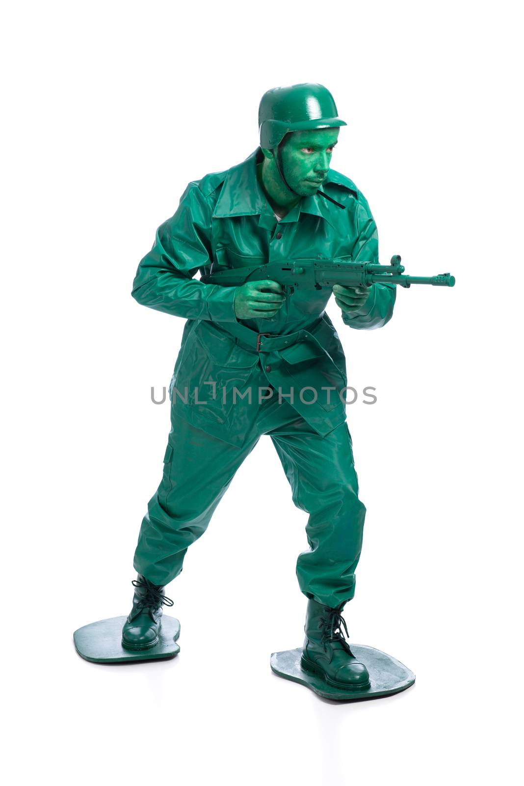 Man on a green toy soldier costume walking with riffle isolated on white background.