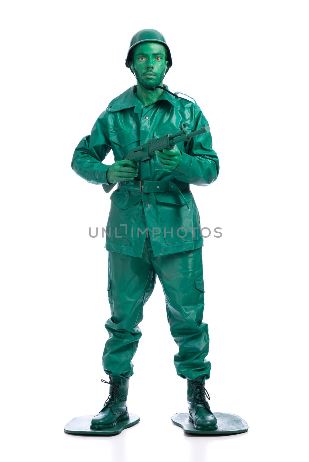 Man on a green toy soldier costume standing with riffle isolated on white background.