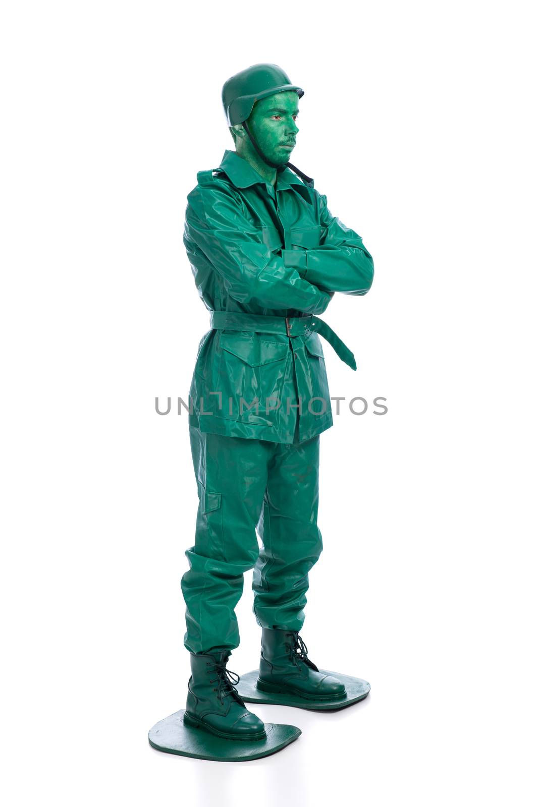 Man on a green toy soldier costume with arms crossed isolated on white background.