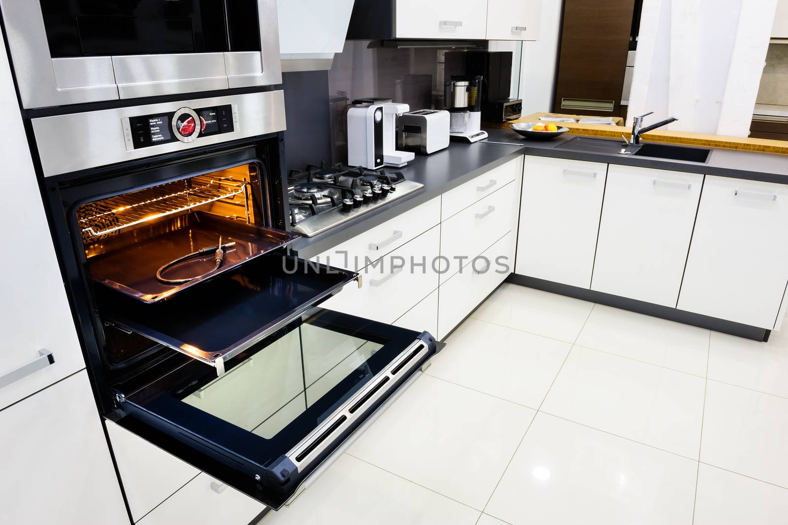 Modern luxury hi-tek black and white kitchen, clean interior design, focu at oven with open door