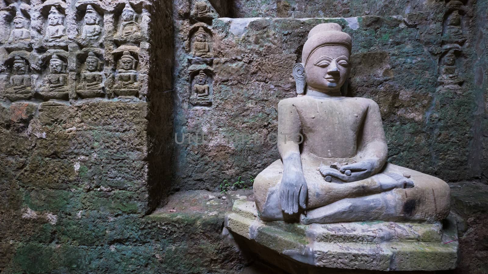 Buddha image with relief in the background at the Koe-thaung Temple, the temple of the 90,000 Buddhas, built by King Min Dikkha during the years 1554-1556 in Mrauk U, Rakhine State in Myanmar.