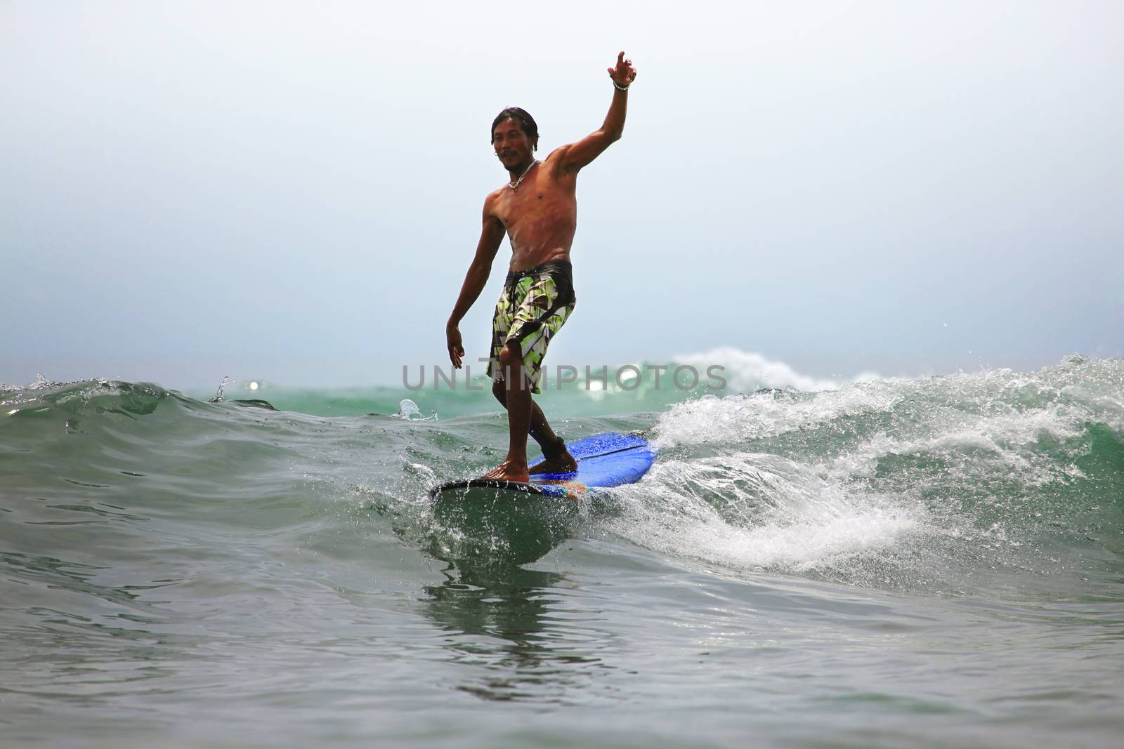 Young men - the surfer in ocean. Bali. Indonesia