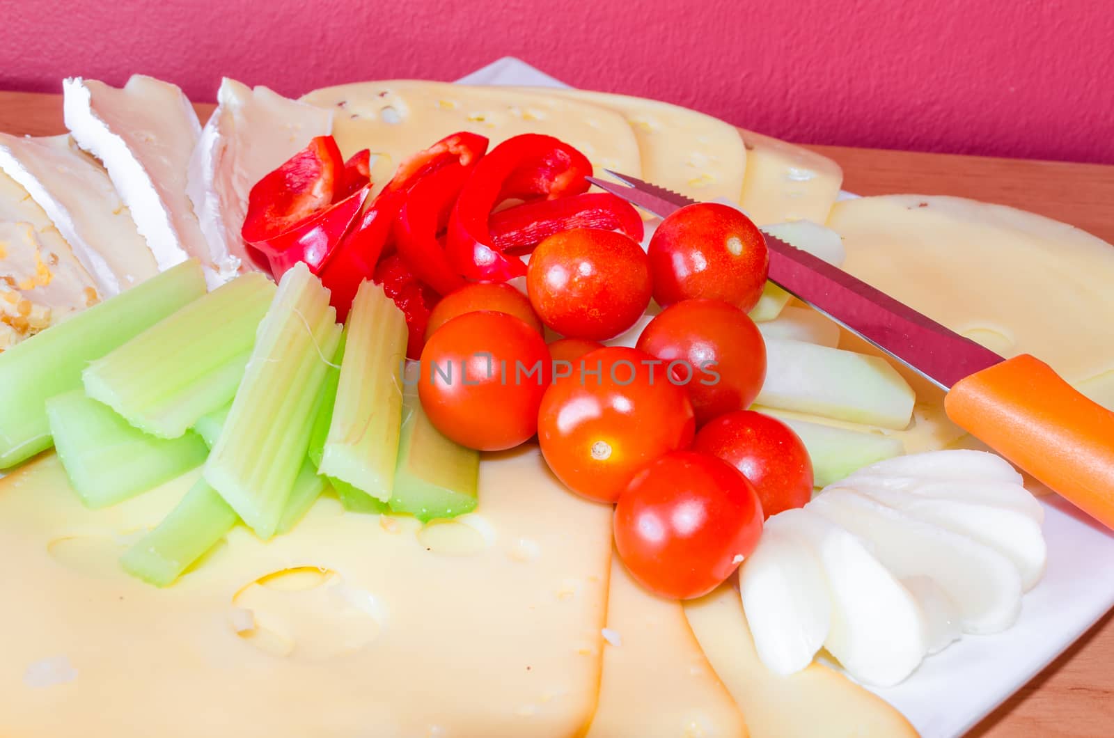 Cheese platter with fruits and vegetables / cheese plate garnished.