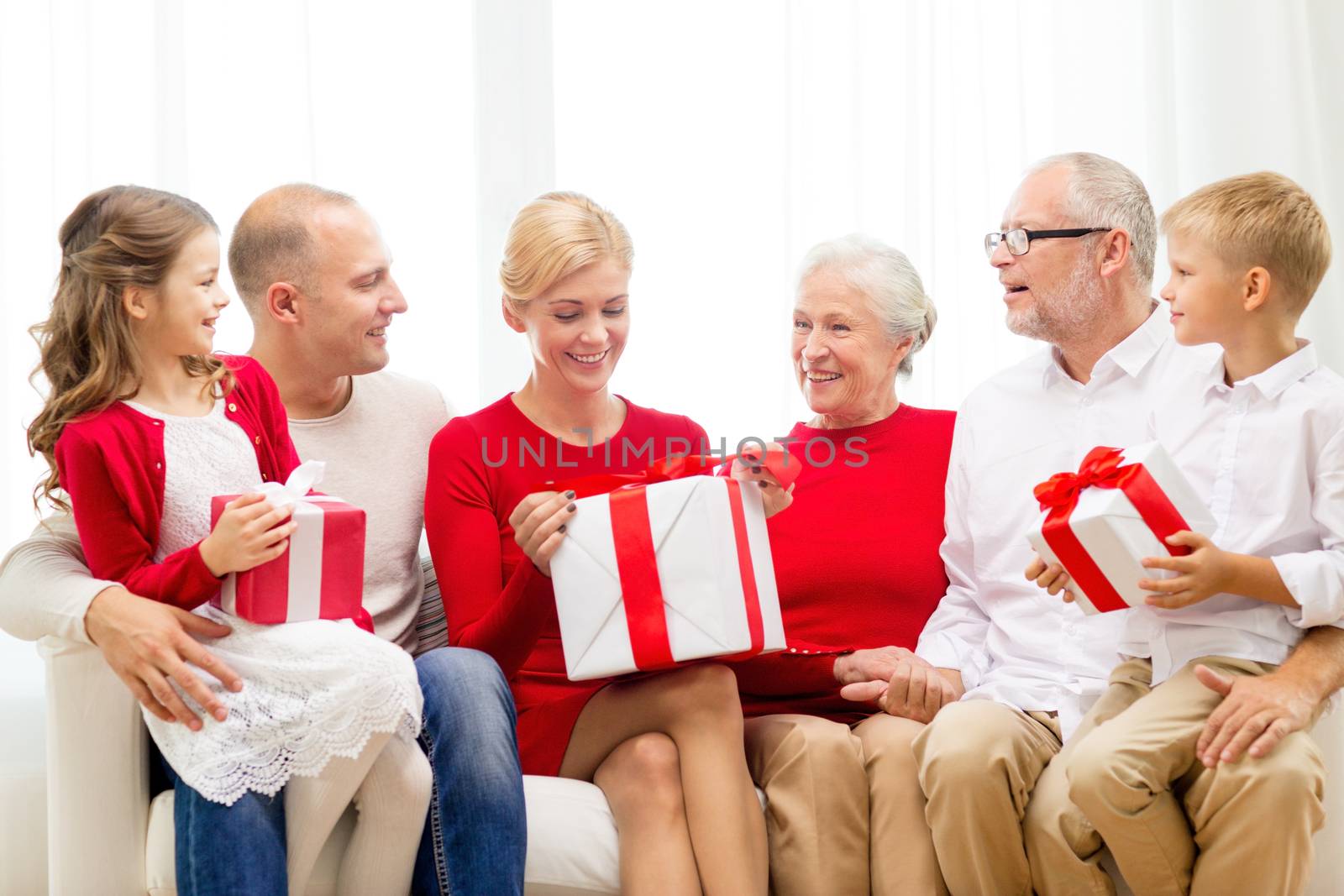 smiling family with gifts at home by dolgachov