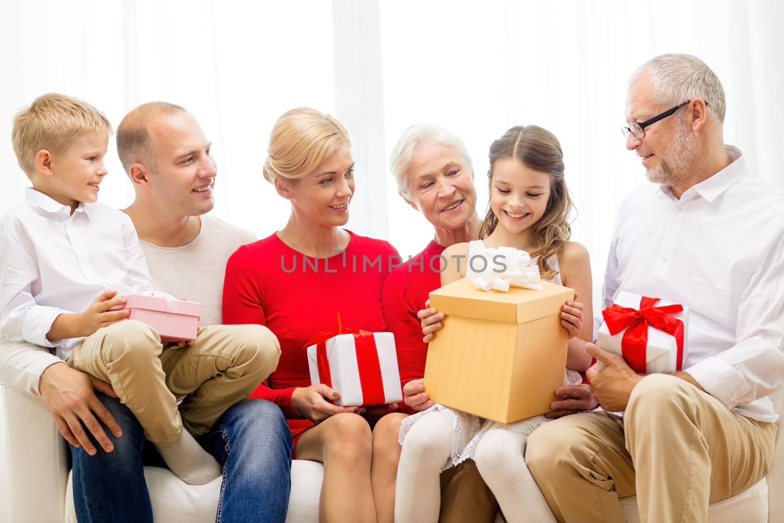 smiling family with gifts at home by dolgachov