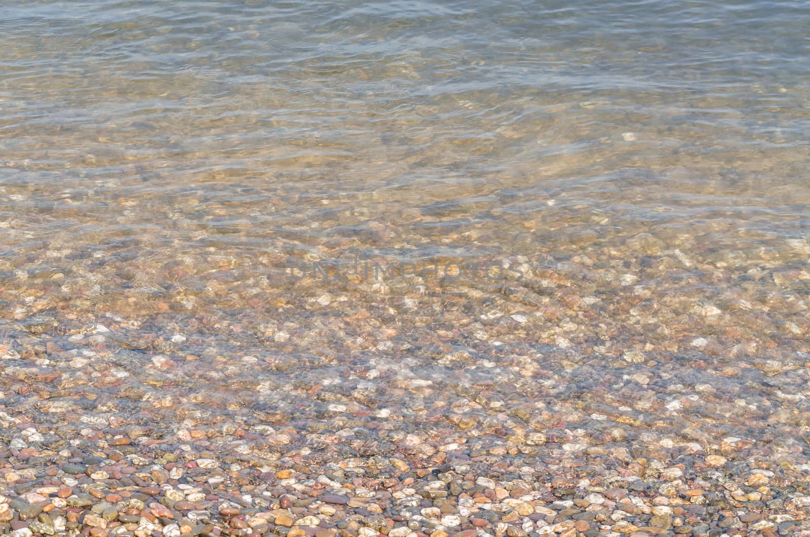 Riverside landscape, view of small pebbles in a clear river.