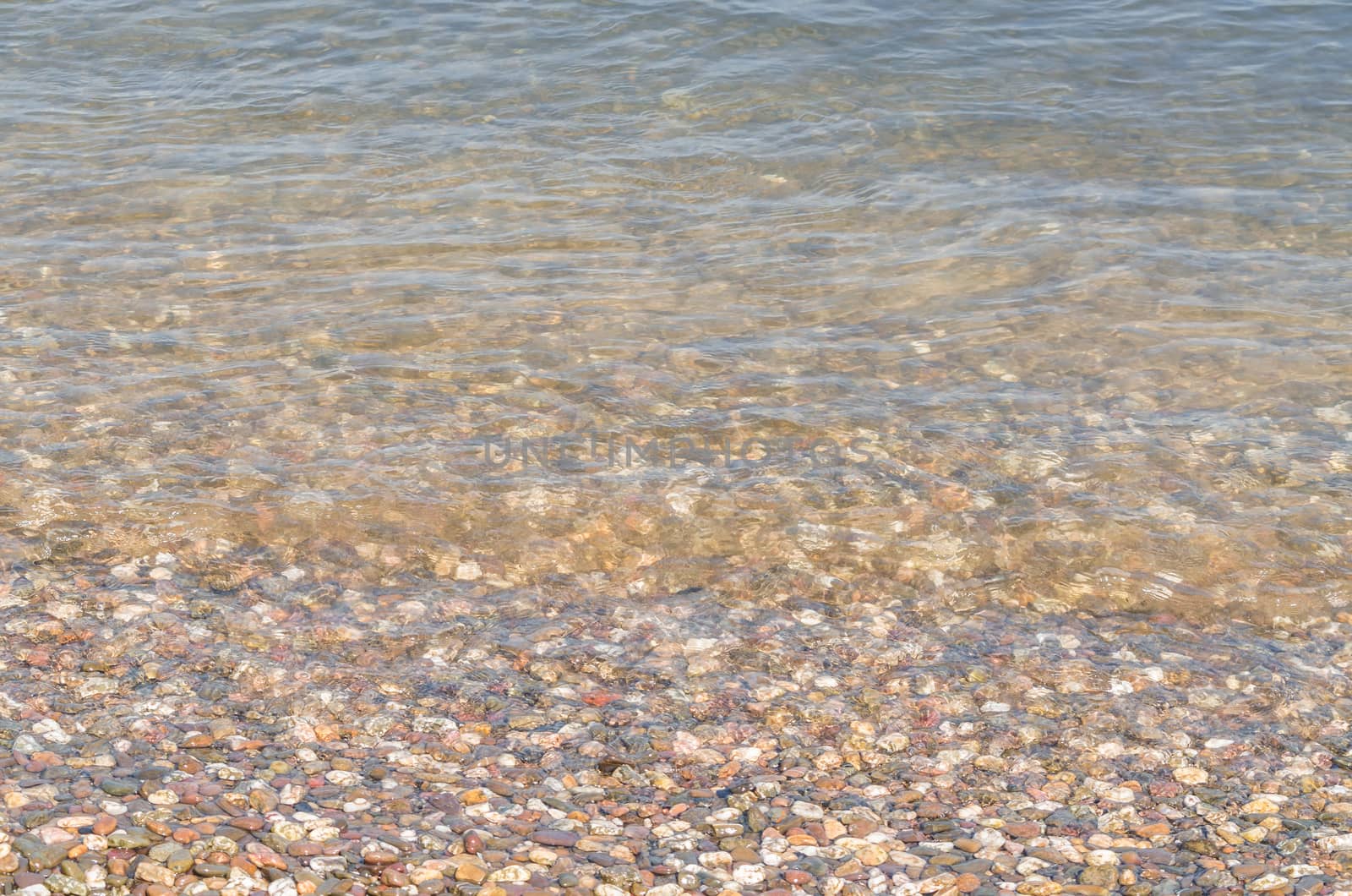 Riverside landscape, view of small pebbles in a clear river.